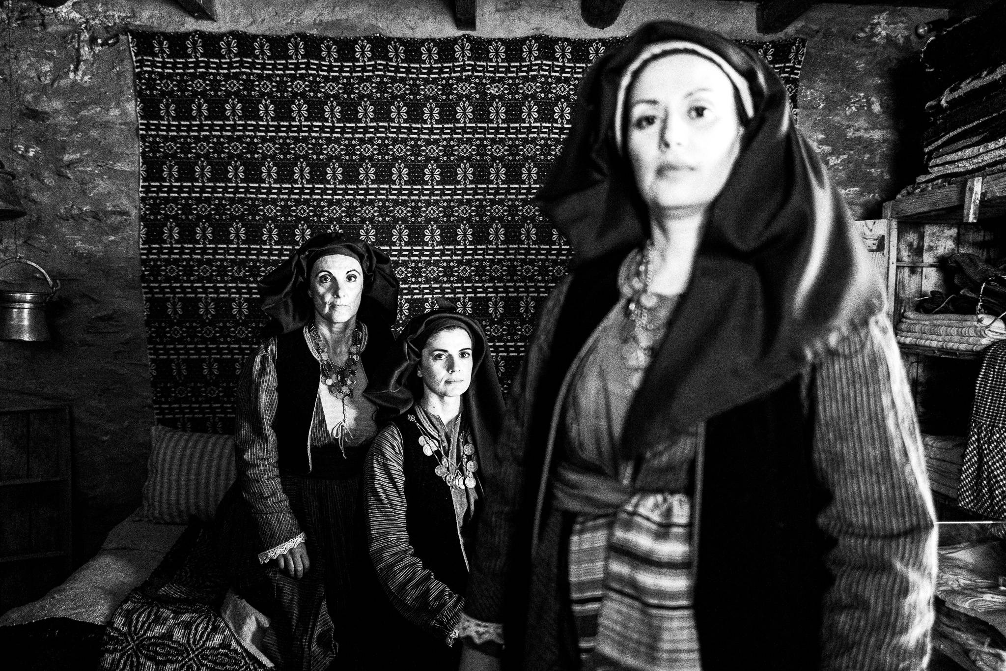 Three women in the traditional costumes of Alagonia, inside the house where Nikitaras was born, in the village of Nedoussa, Peloponnese, Greece