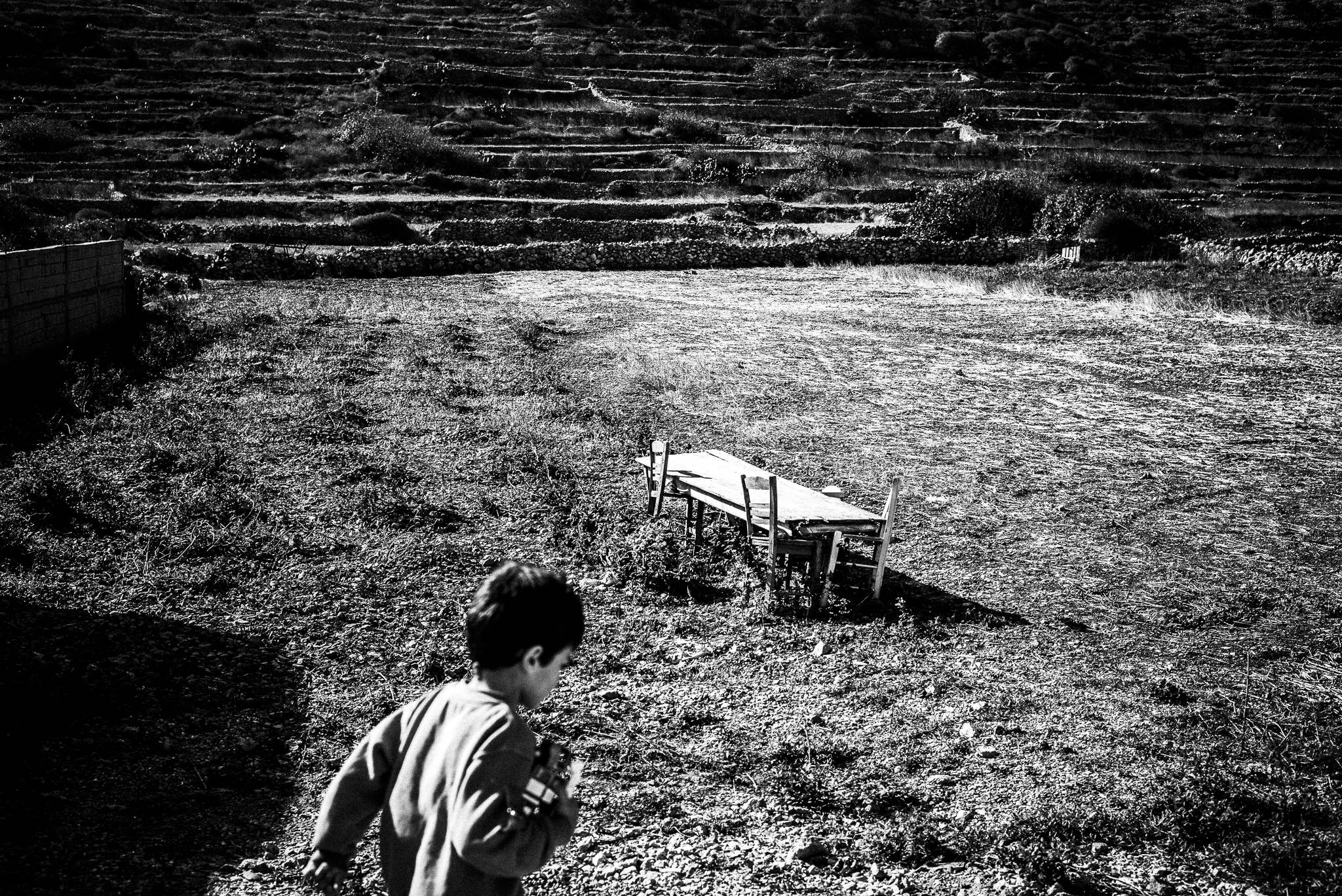 Children playing in Avlona, Olympos, Karpathos, Greece. Black and white photography by George Tatakis