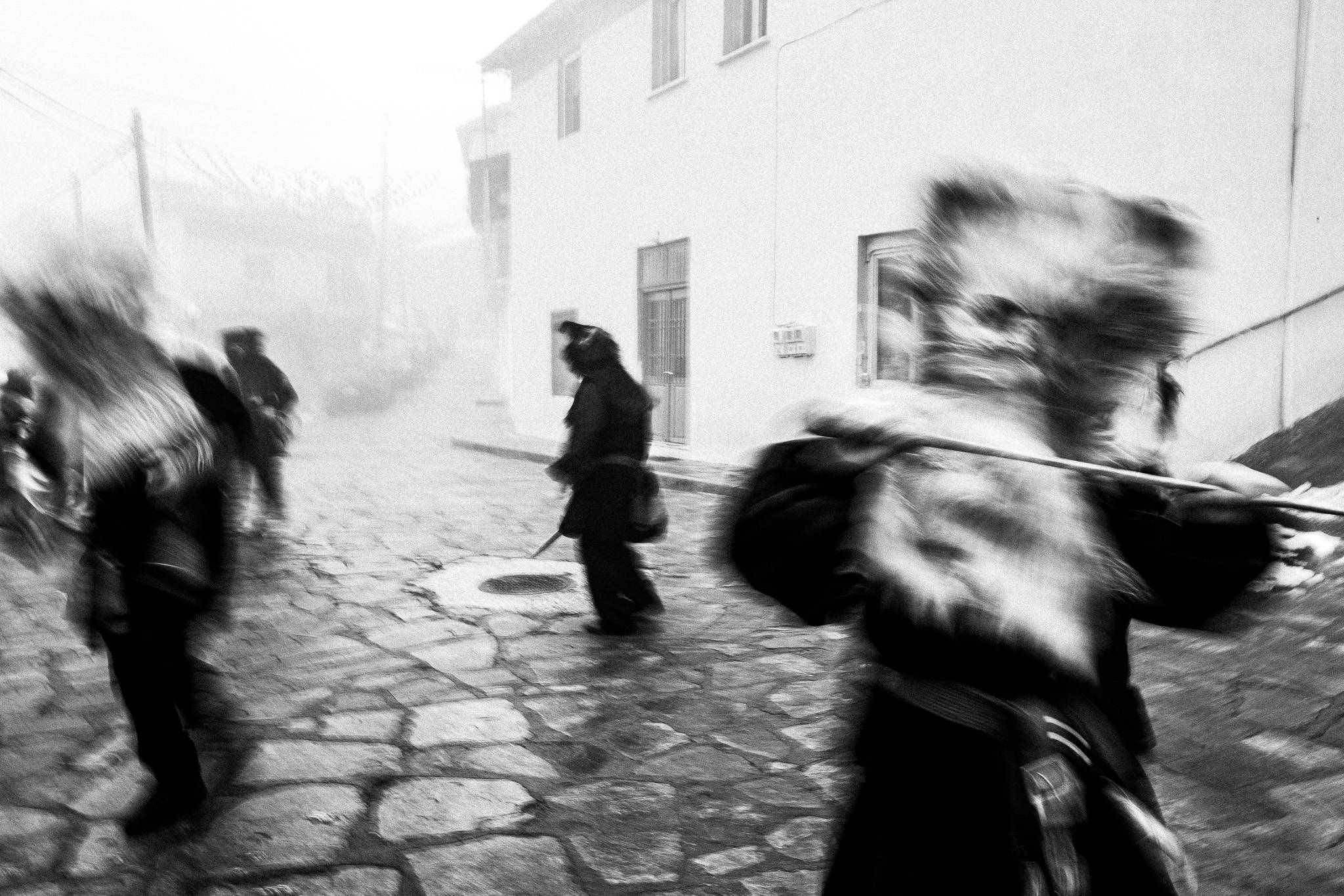Charapides of Pagoneri performing at the main square, Pagan Christmas customs of Northern Greece, by photographer George Tatakis