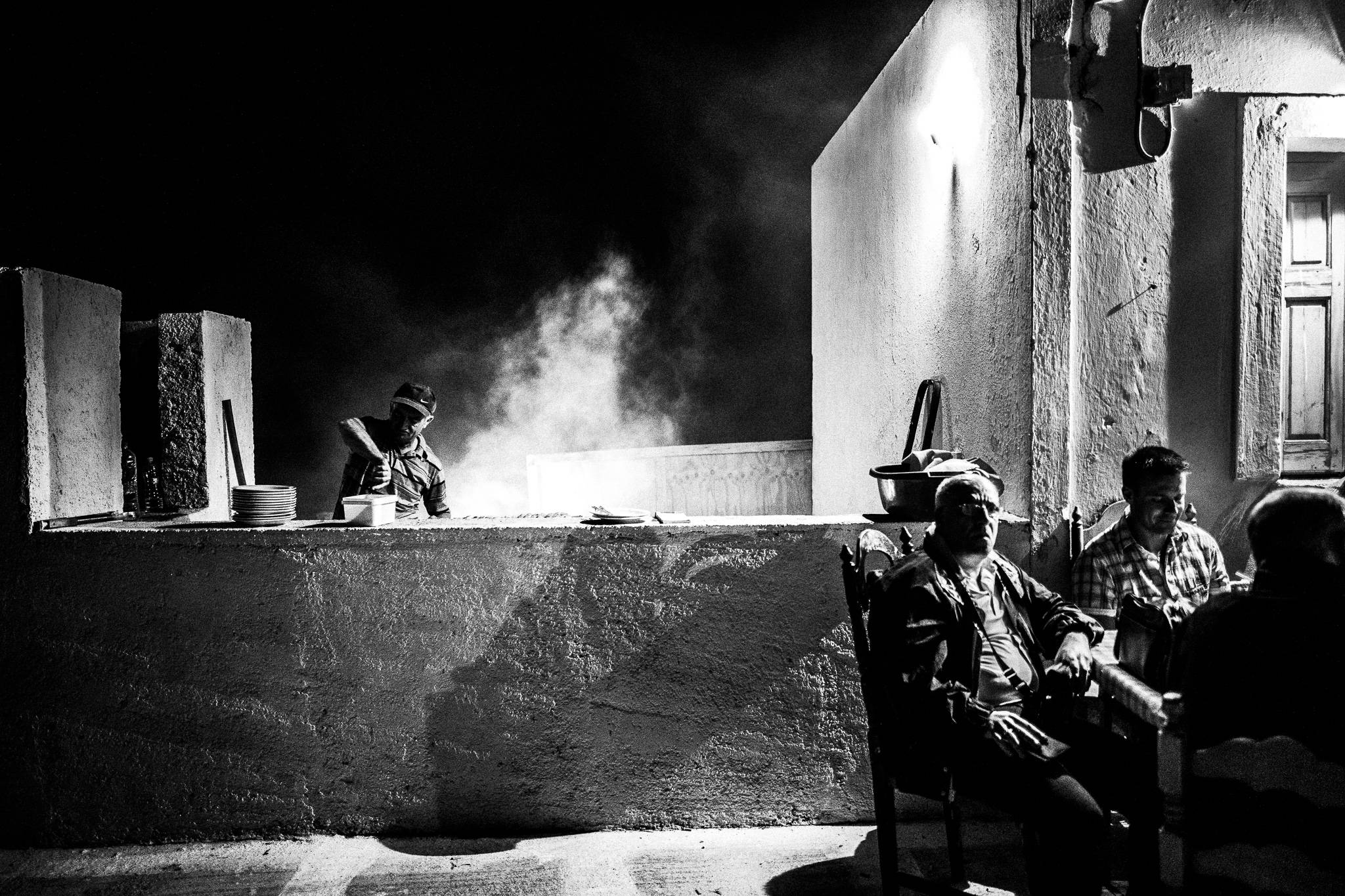 Cooking food during the ‘Avlona Days’, Olympos, Karpathos, Greece. Black and white photography by George Tatakis