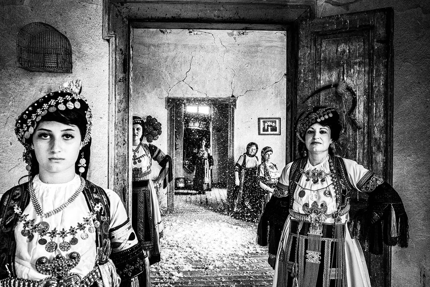 Μια παρέα γυναικών μέσα σε ένα παλιό Αρχοντικό στο Γλίνο, φορώντας τα παραδοσιακά φορέματα Καραγκούνα των Τρικάλων, Θεσσαλία, Ελλάδα. Ασπρόμαυρη φωτογραφία του Γιώργου Τατάκη