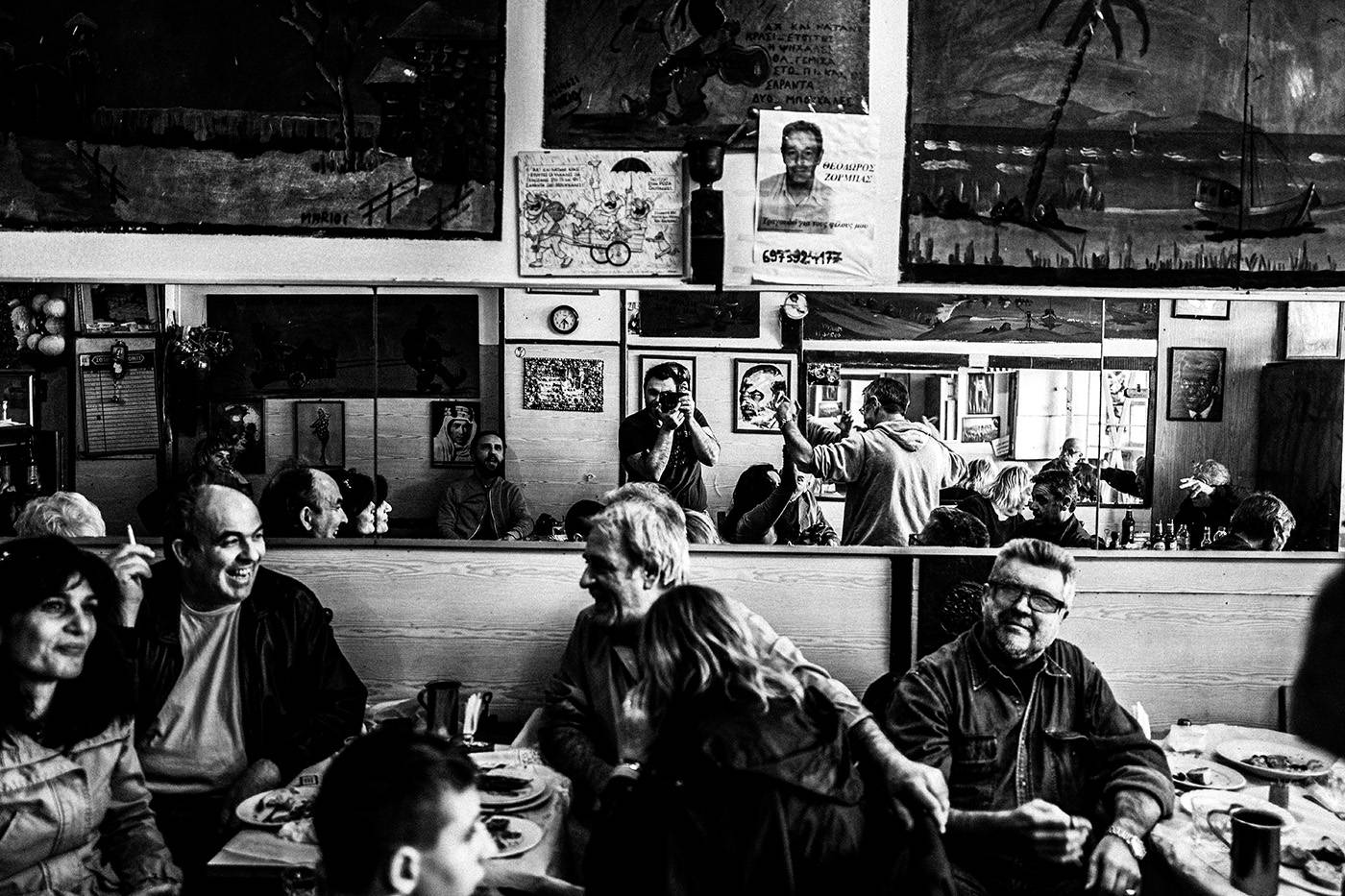 Άνθρωποι μέσα στο καφέ Θεόκλητος - Ένα κρυμμένο στολίδι στον Πειραιά, Ελλάδα. Ασπρόμαυρη φωτογραφία του Γιώργου Τατάκη