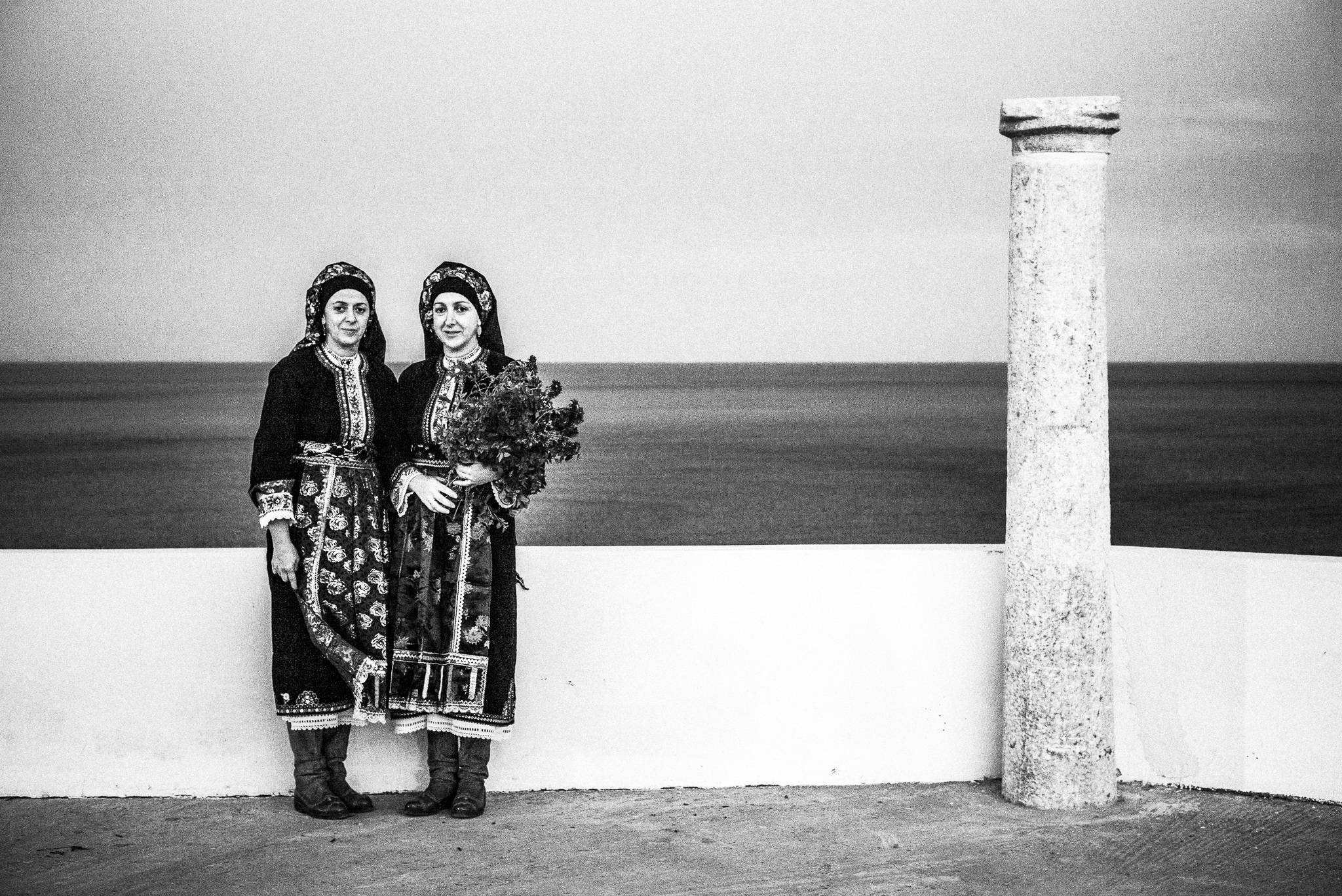 Women in the traditional kava’e during the festival of St. Minas, Olympos, Karpathos, Greece. Black and white photography by George Tatakis