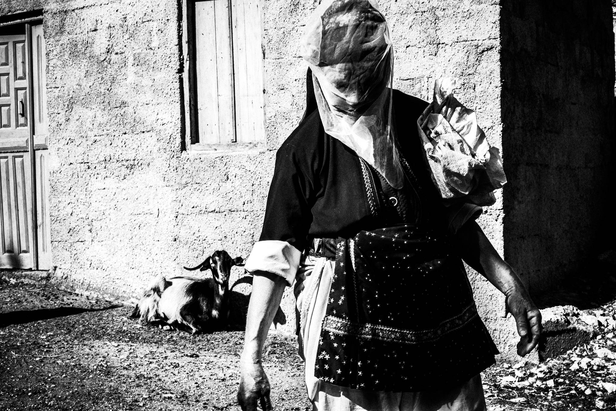Wearing a protective veil, Olympos, Karpathos, Greece. Black and white photography by George Tatakis