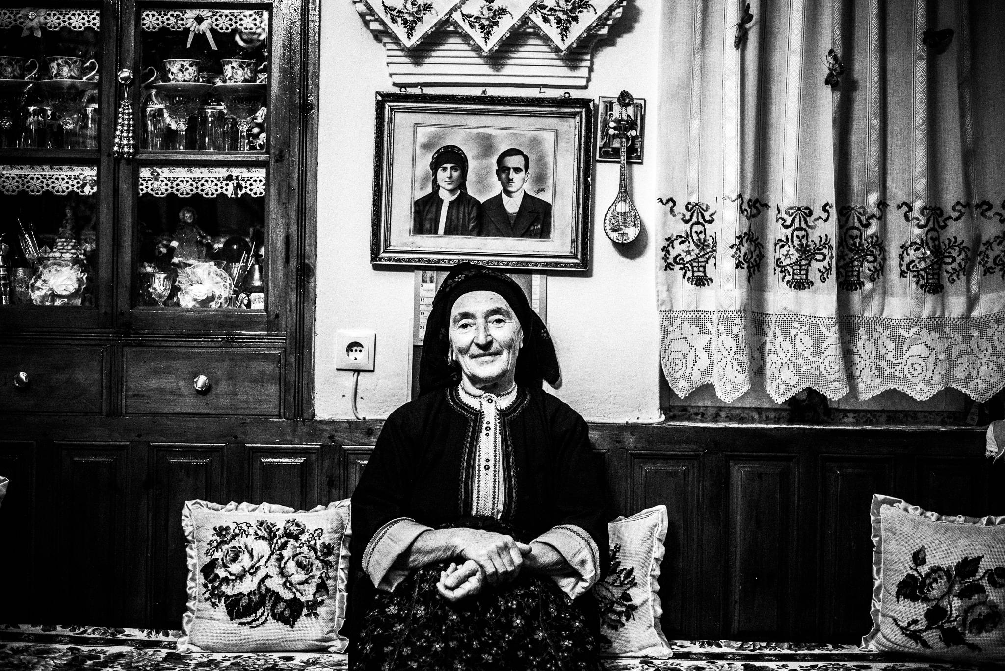 Papa Yannis’ wife, Irene, inside her home in Olympos, Karpathos, Greece. Black and white photography by George Tatakis