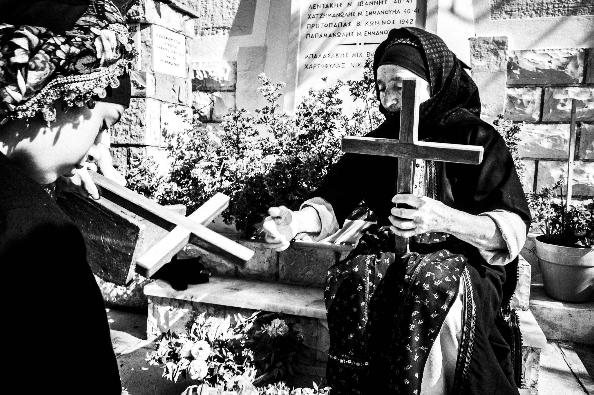 A girl with her grandmother, decorating wooden crosses for the Epitaphios. Olympos, Karpathos, Greece
