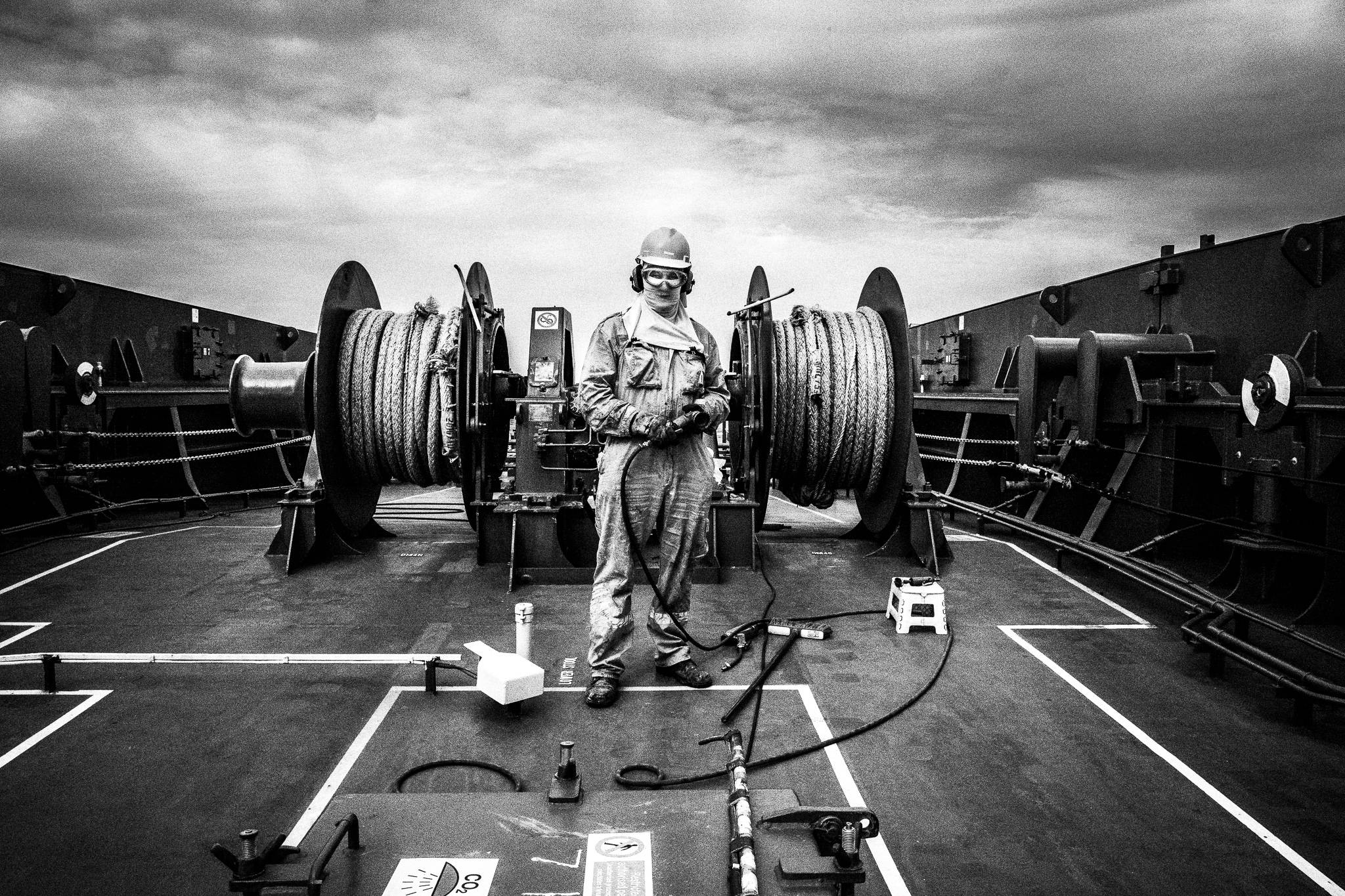 Doing chores on deck using protective gear by photographer George Tatakis