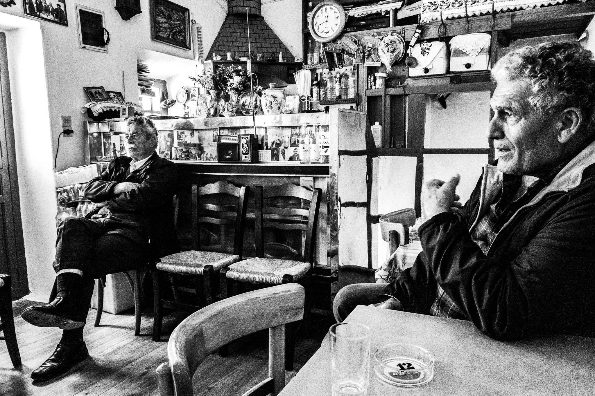 Two men discussing inside a local traditional café, in Olympos, Karpathos, Greece
