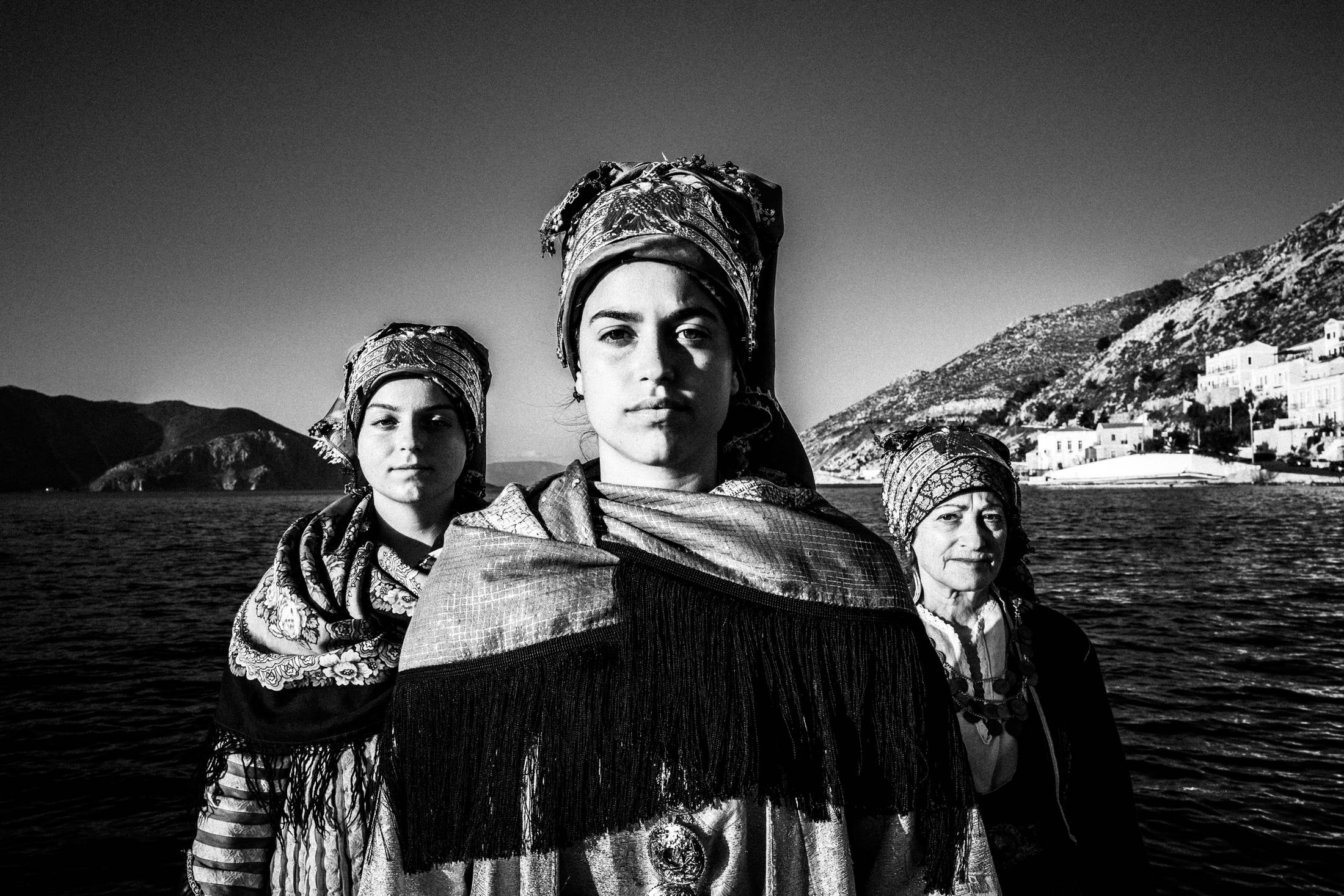 Traditional costumes at the harbour of Symi, by photographer George Tatakis