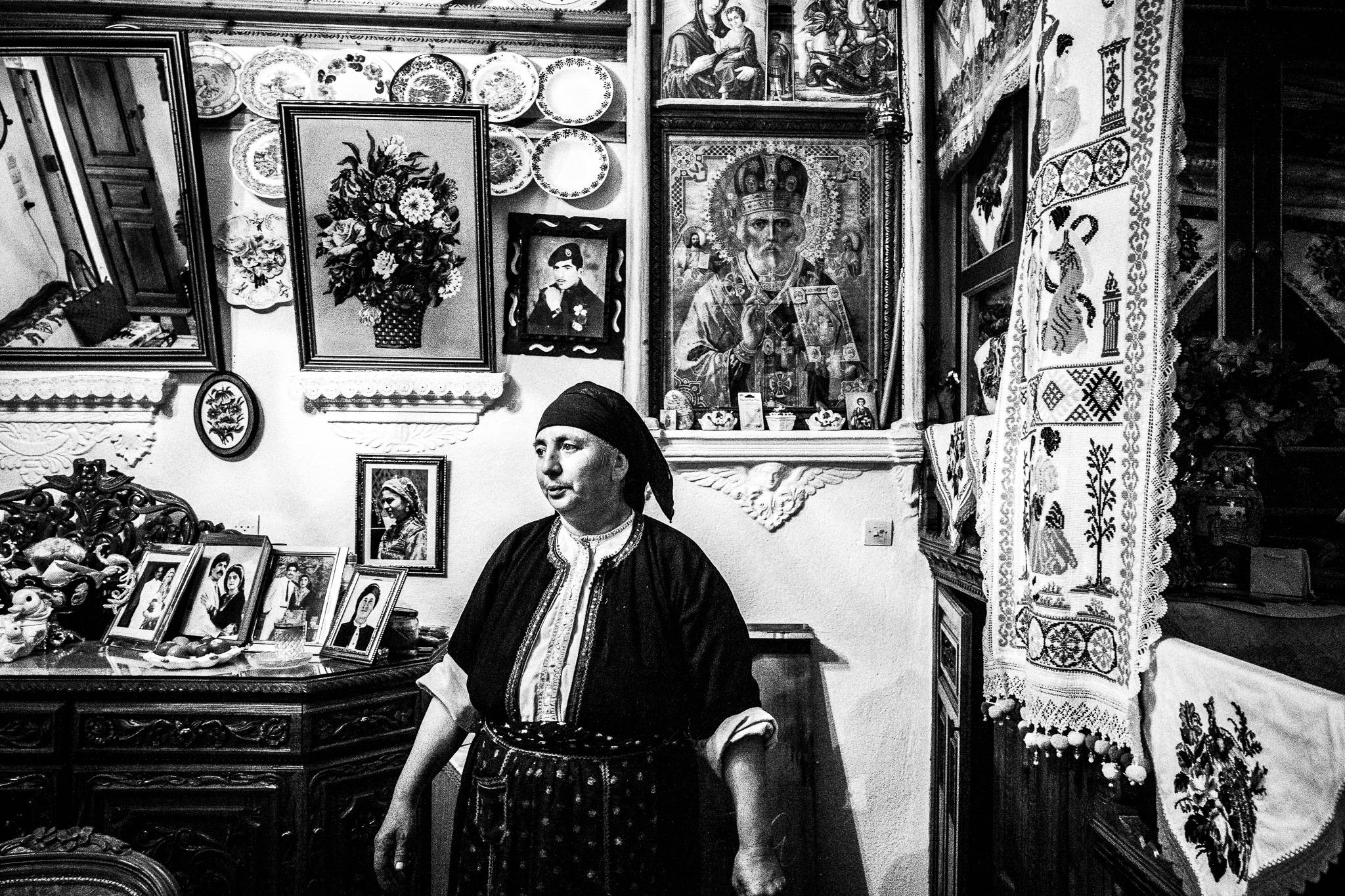 A local baker, in her traditional costume, inside her traditional home. Olympos, Karpathos, Greece