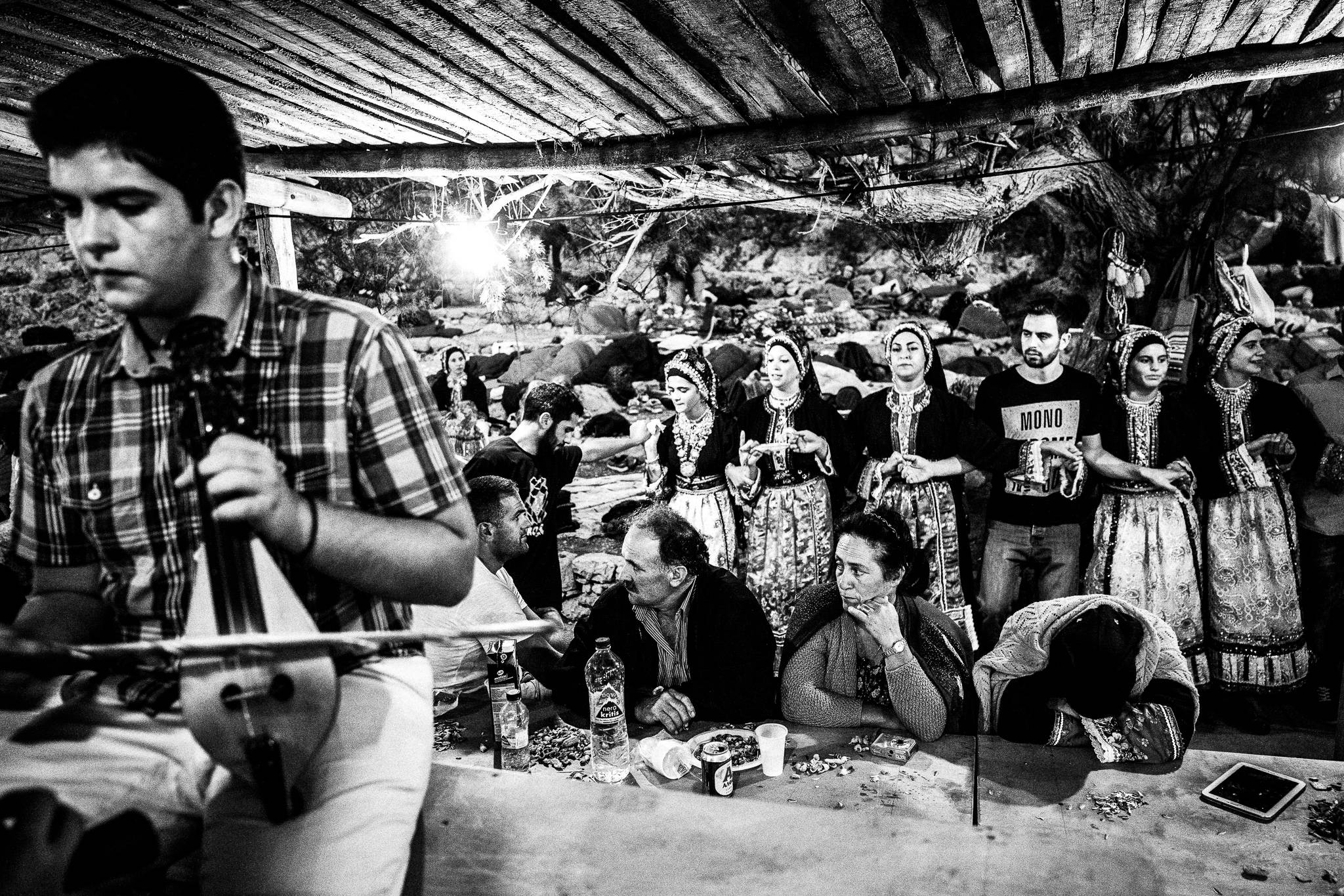 Dancing continues till the early morning at the feast of Saint John at the site of the ancient city of Brykous, Olympos, Karpathos, Greece. Black and white photography by George Tatakis