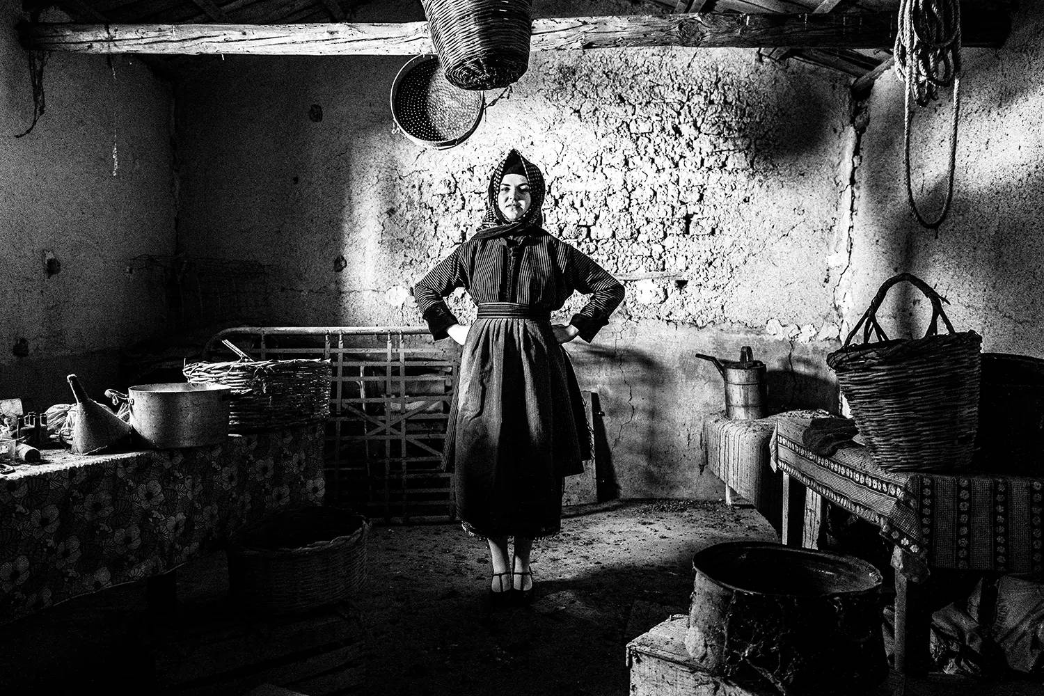 A girl inside an old warehouse, wearing the folklore attire of Stefanovikio, Thessaly, Greece. Black and white photography by George Tatakis.