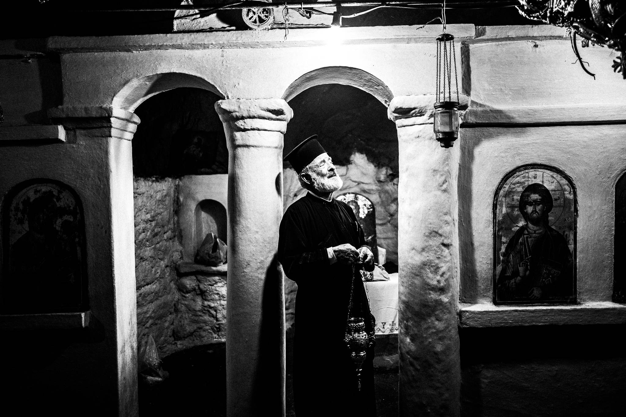 Inside the cave Church of St. John at the ancient city of Brykous, Olympos, Karpathos, Greece. Black and white photography by George Tatakis