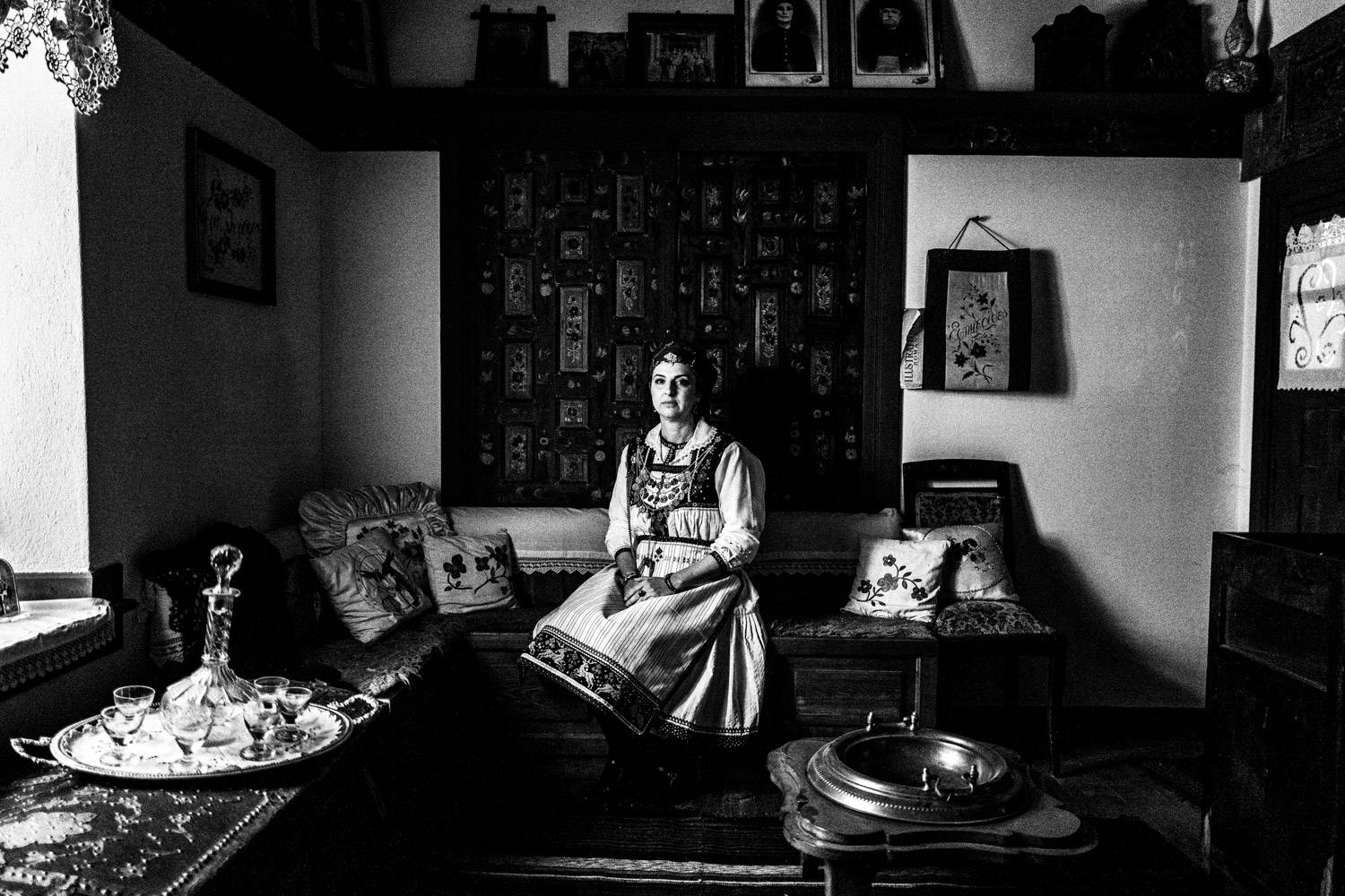 Sitting portrait of a woman, inside a Mansion in Siatista, wearing the costume of Tsartsampas, Macedonia, Greece. Black and white photograph by George Tatakis