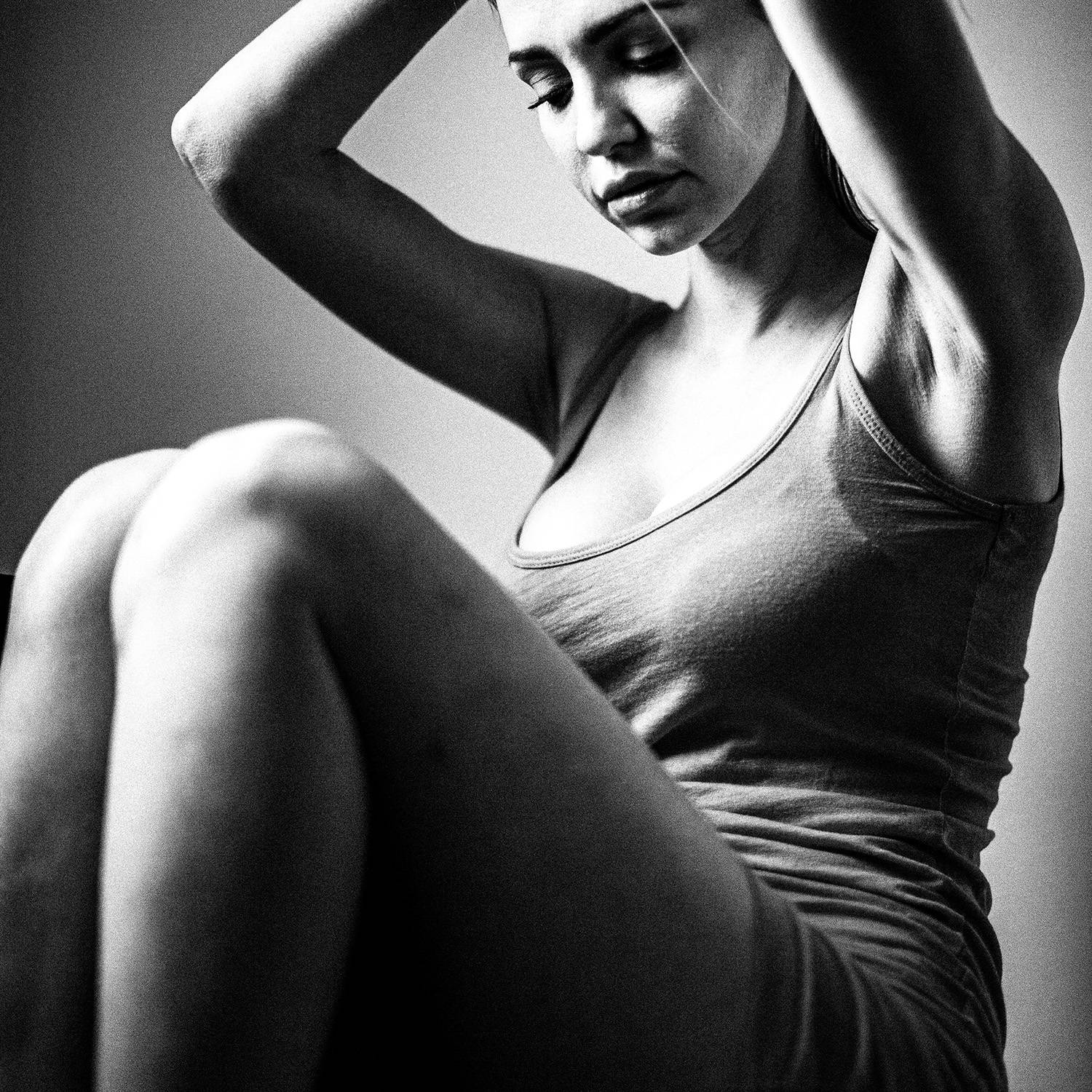 Black and white photograph of a model posing inside a studio