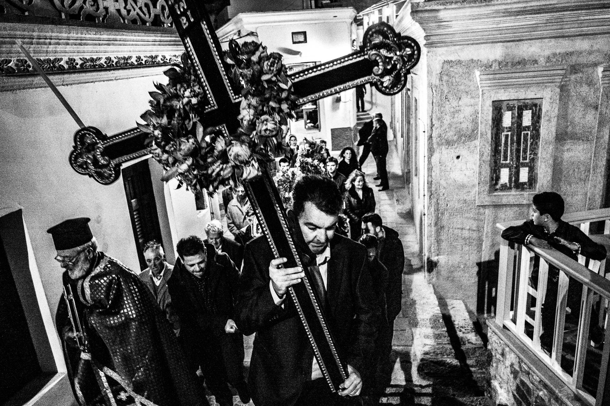 The procession of the Epitaphios on Good Friday. Carrying a large wooden cross. Olympos, Karpathos, Greece