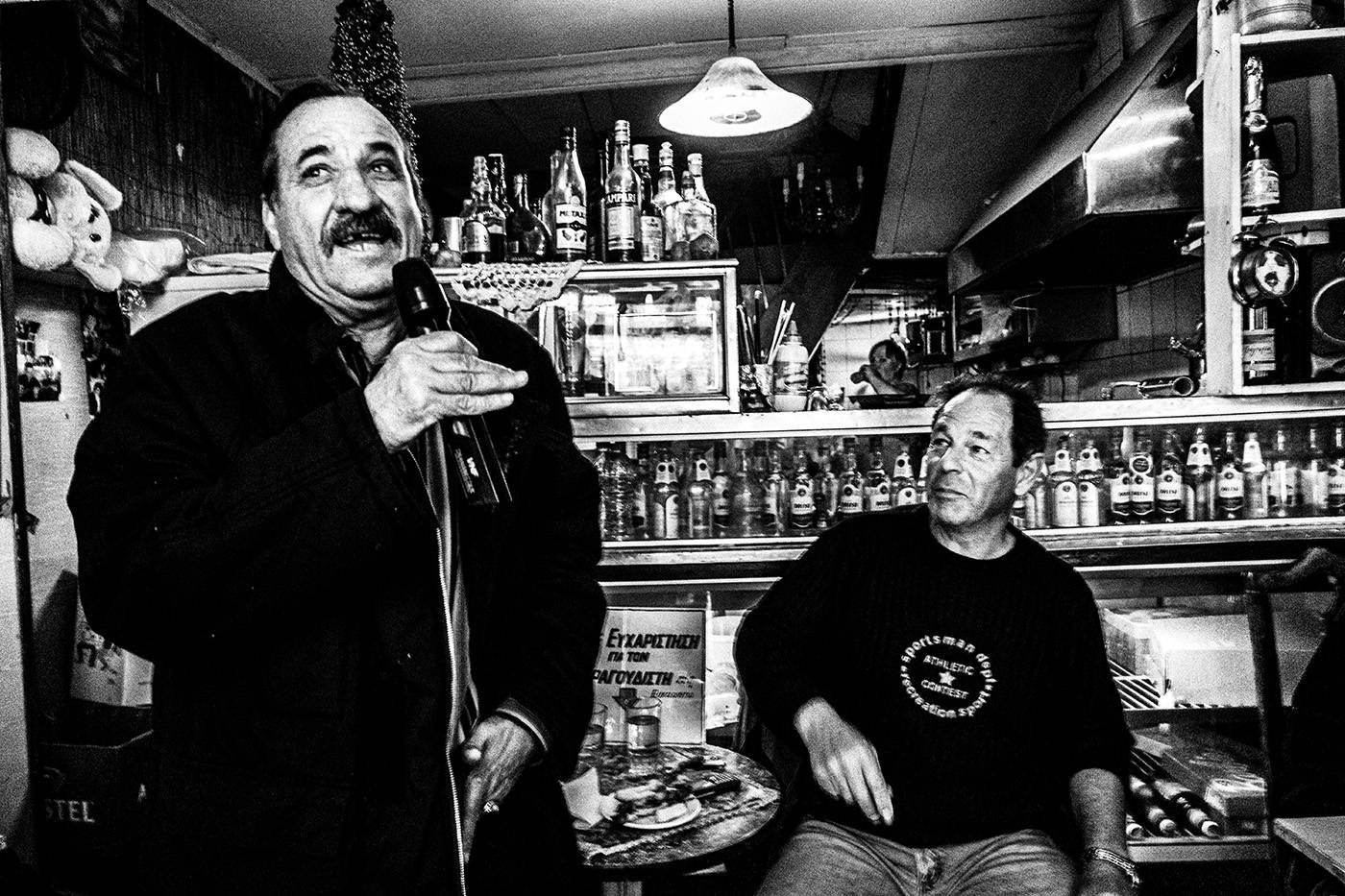 Καραόκε στο καφενείο Θεόκλητος - Ένα κρυμμένο στολίδι στον Πειραιά, Ελλάδα. Ασπρόμαυρη φωτογραφία του Γιώργου Τατάκη