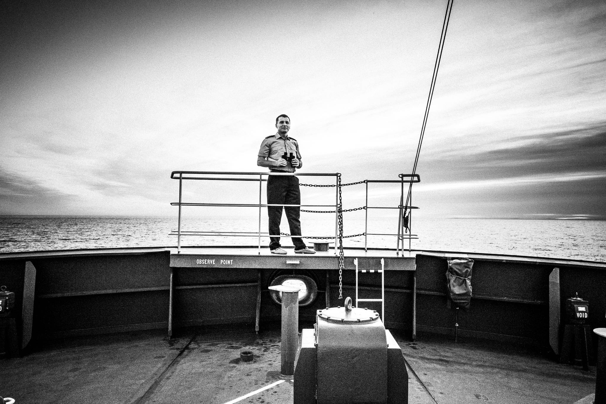 The captain on the deck, holding his binoculars, by photographer George Tatakis