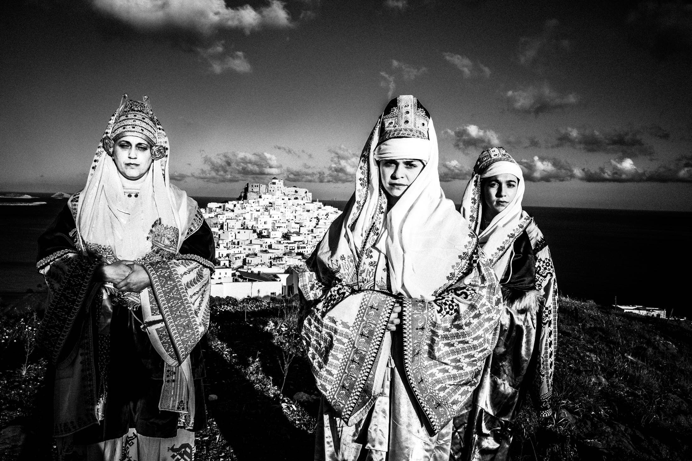 The ladies wearing the traditional costumes of Astypalaea, overlooking the town and the castle, by photographer George Tatakis