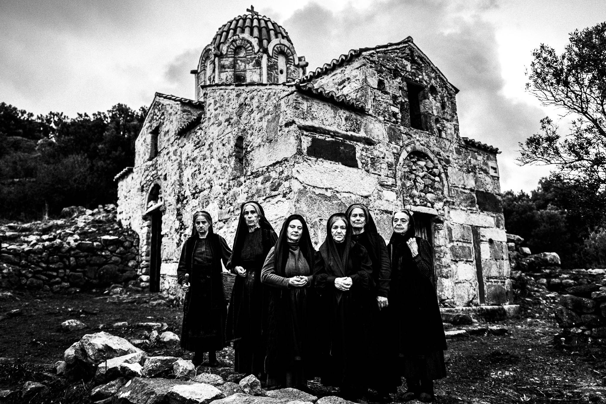 Group portrait at the church. Black and white photography by George Tatakis during the filming of 'Φόνισσα'(Fonissa).