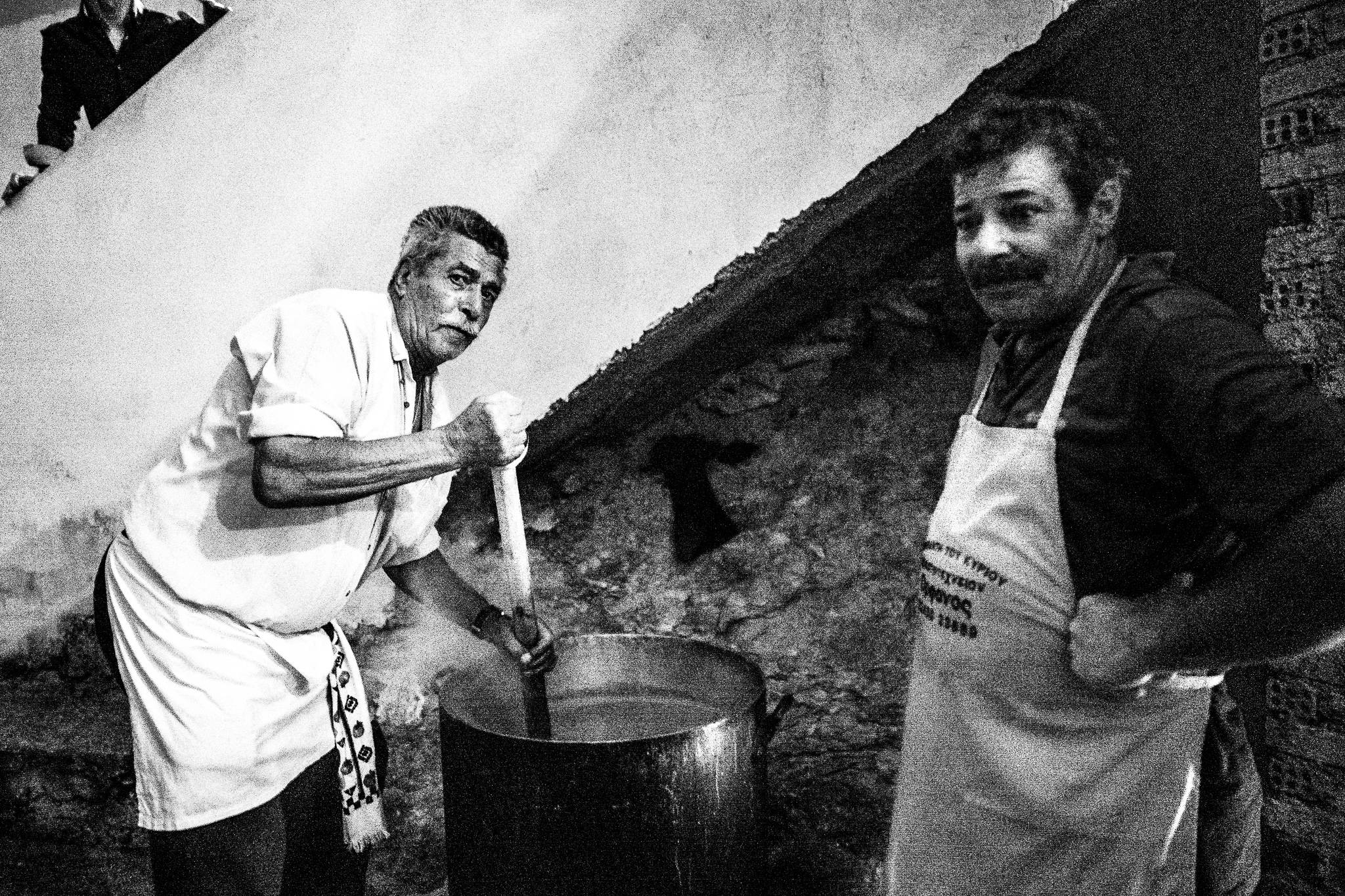 Cooking for the reception in Olympos, Karpathos, Greece. Black and white photography by George Tatakis