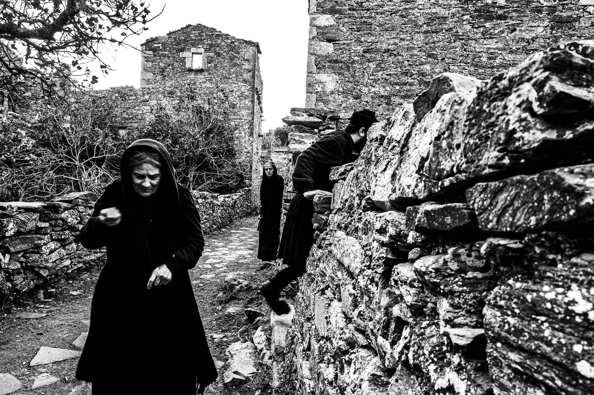 An awkward meeting during the funeral. Black and white photography by George Tatakis during the filming of 'Φόνισσα'(Fonissa).