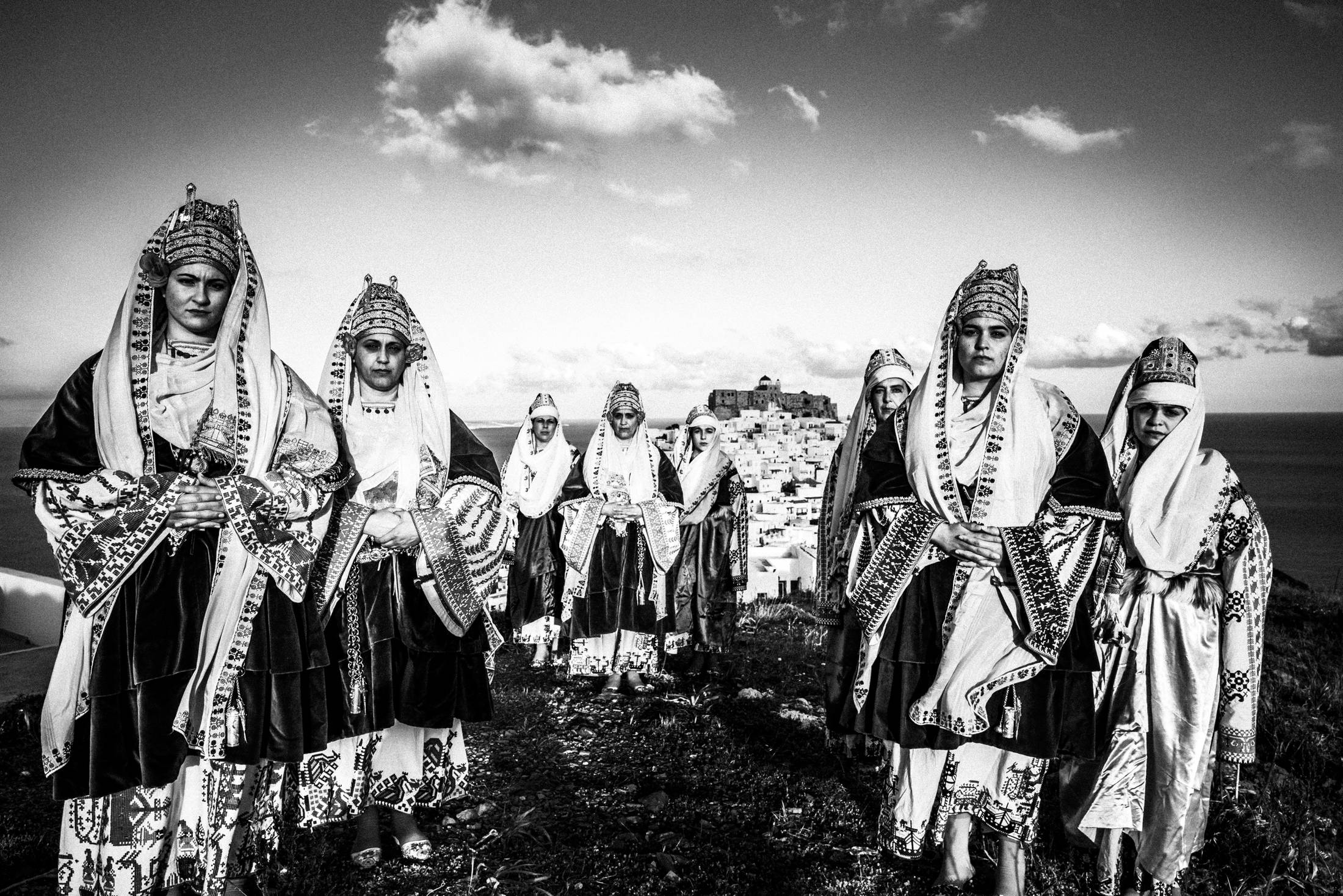 The ladies wearing the traditional costumes of Astypalaea, overlooking the town and the castle, by photographer George Tatakis