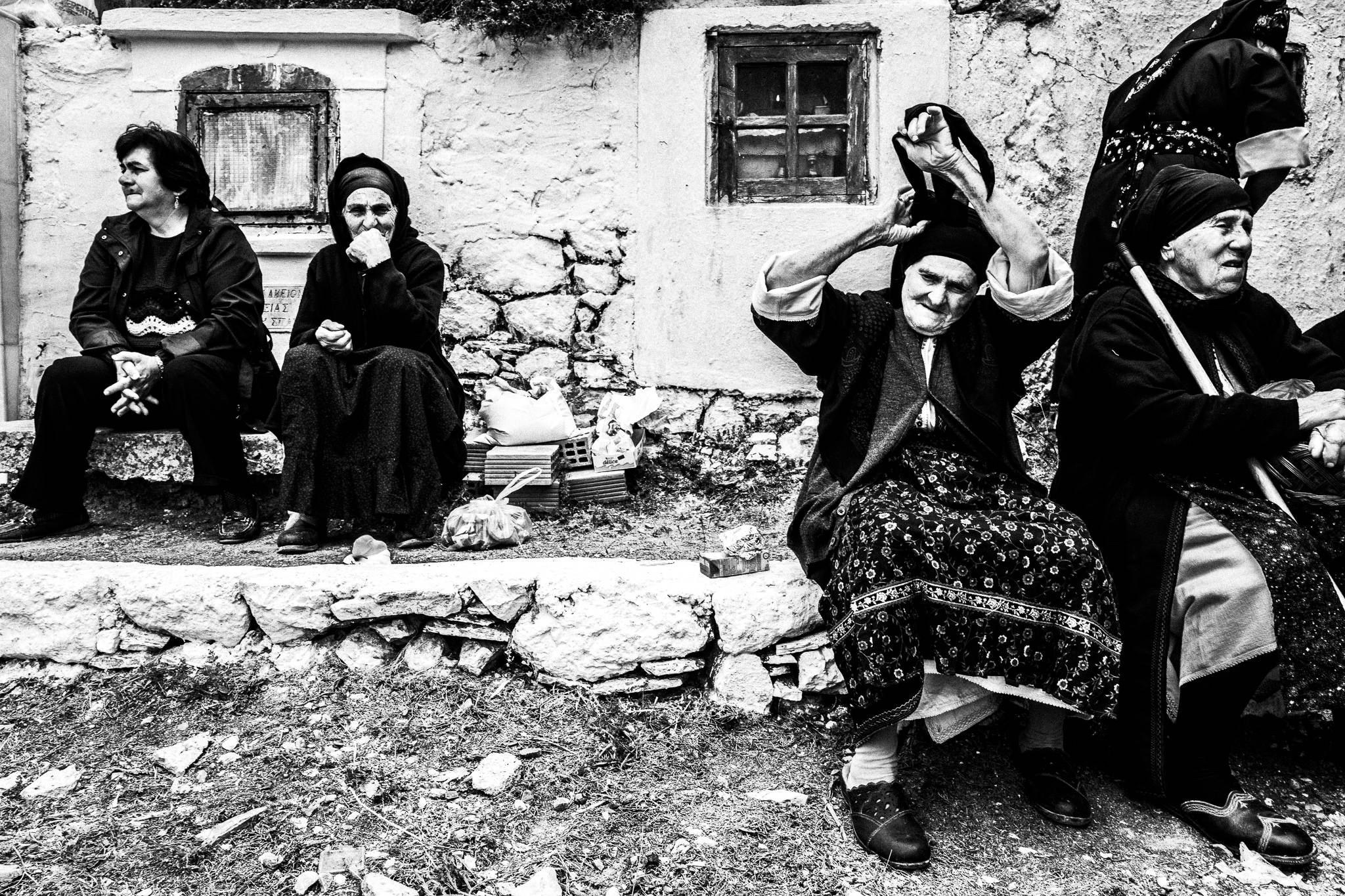 Four women sitting at the local cemetery. Olympos, Karpathos, Greece. 