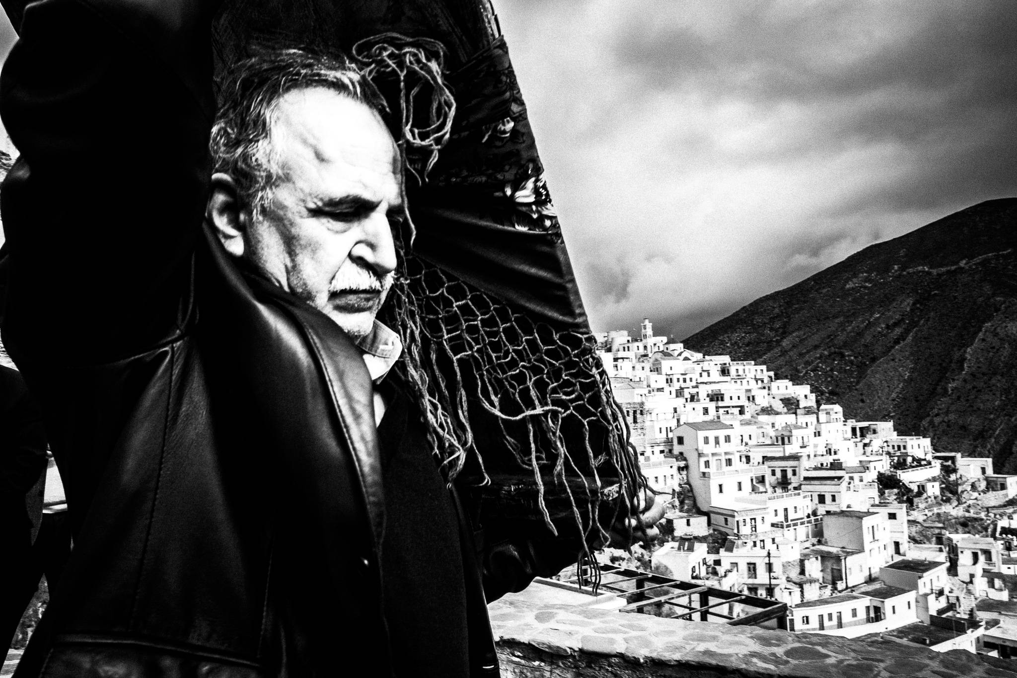 A man carrying a heavy wooden Orthodox Icon across the village on Easter Tuesday. Olympos, Karpathos, Greece. 