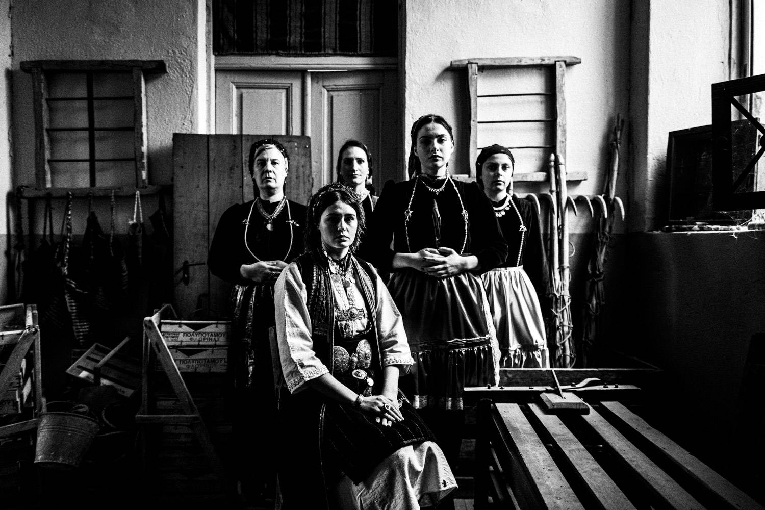 Five women wearing the local folklore dresses, at the local folklore museum. Polypotamos, Florina, Macedonia, Greece. Black and white photograph by George Tatakis