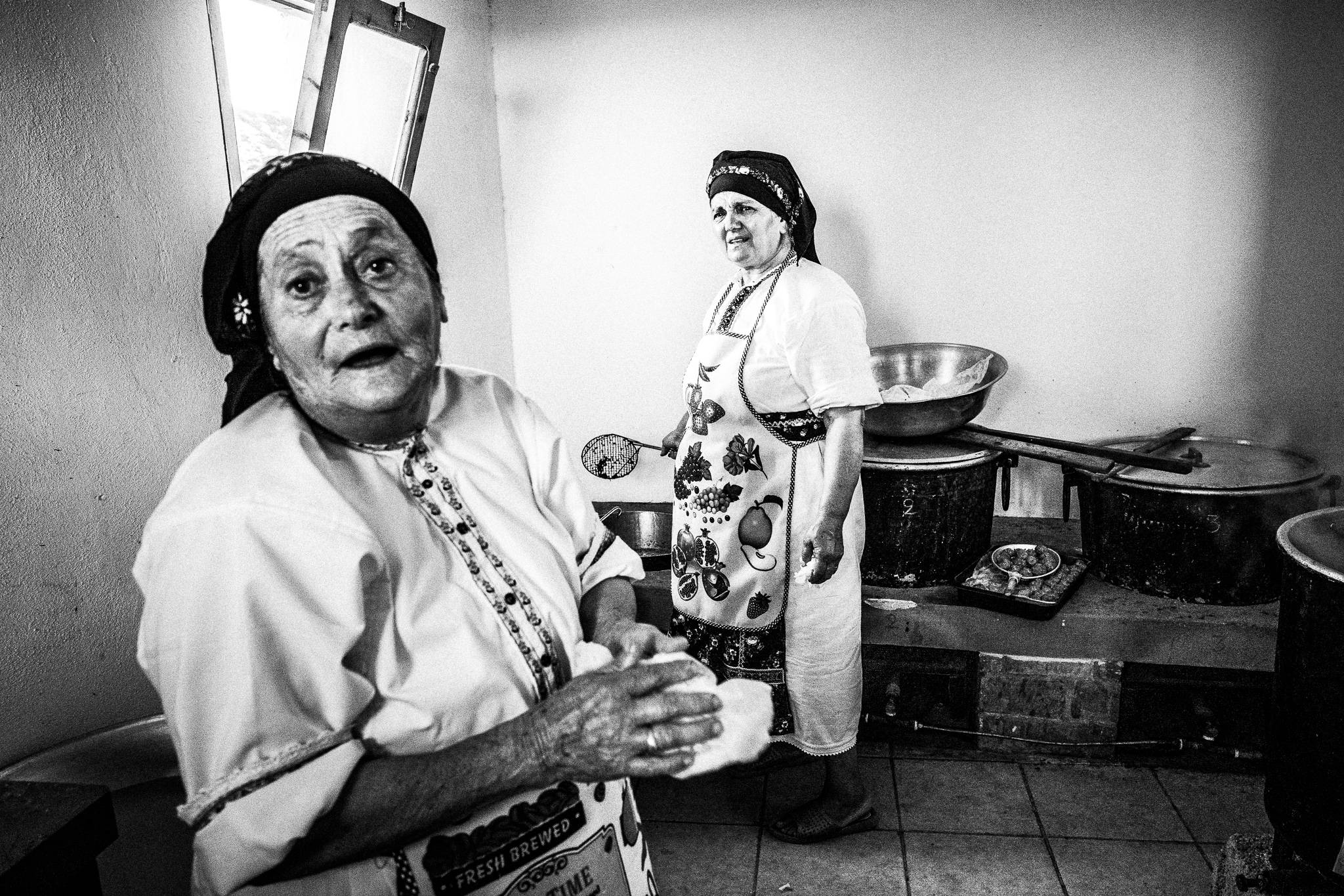 Cooking food for the guests at a traditional baptism in St. Minas, Olympos, Karpathos, Greece. Black and white photography by George Tatakis