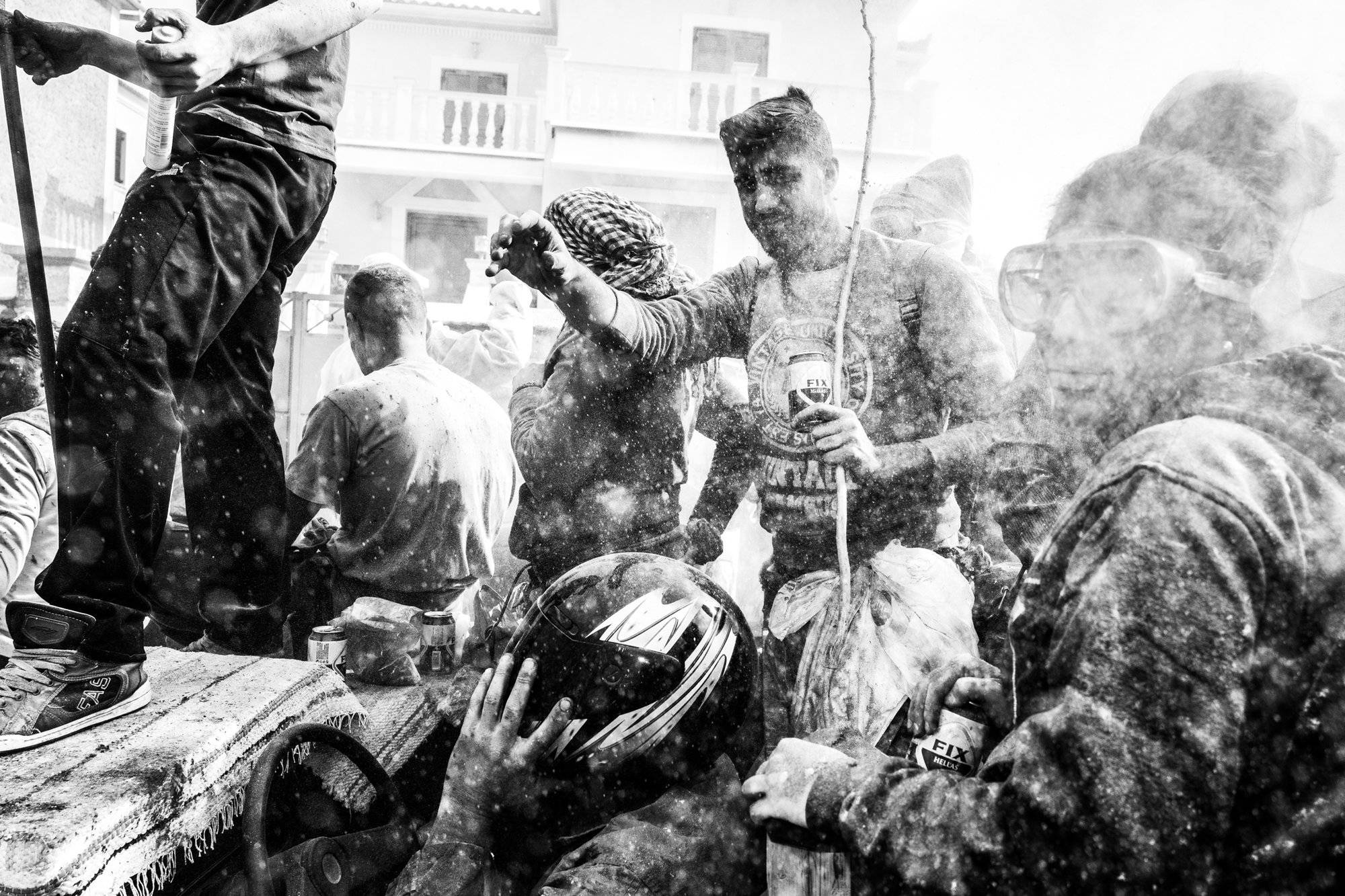 Using a helmet for protection at the flour wars of Galaxidi, by photographer George Tatakis
