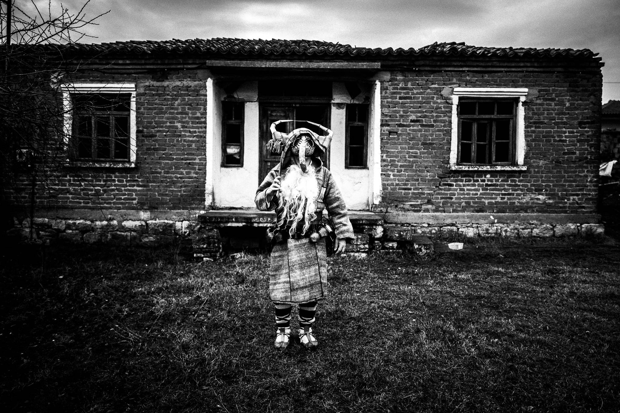 Purpuris in front of a house, Pagan Christmas customs of Northern Greece, by photographer George Tatakis