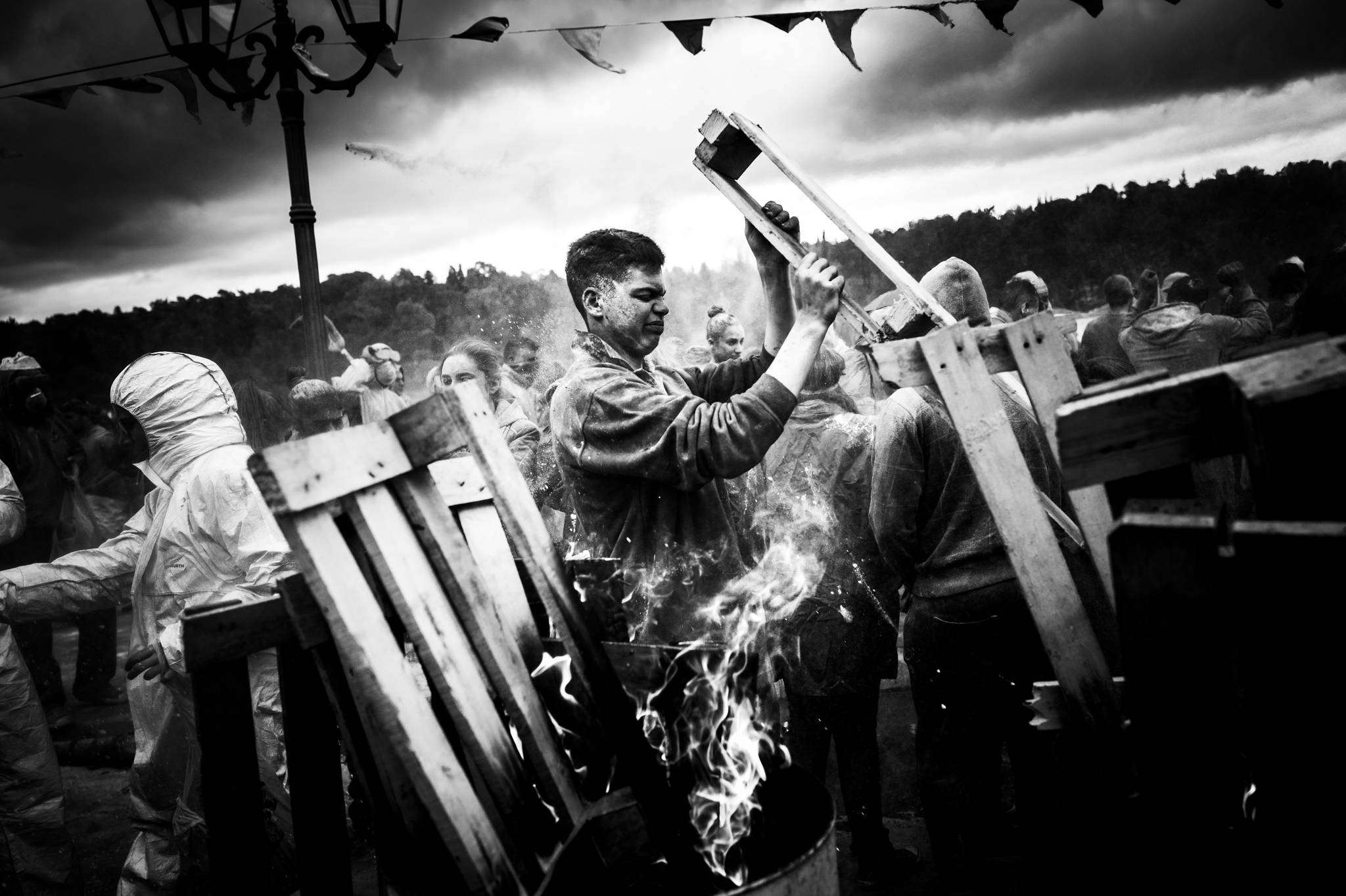 Adding wood to the bonfire at the port during the flour wars of Galaxidi, by photographer George Tatakis