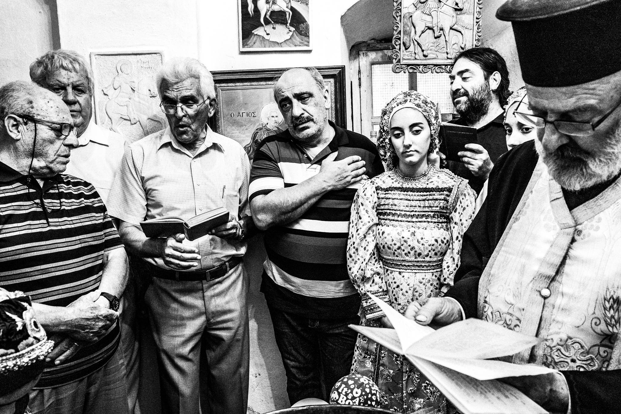 Chanting in the church at a traditional baptism in St. Minas, Olympos, Karpathos, Greece. Black and white photography by George Tatakis