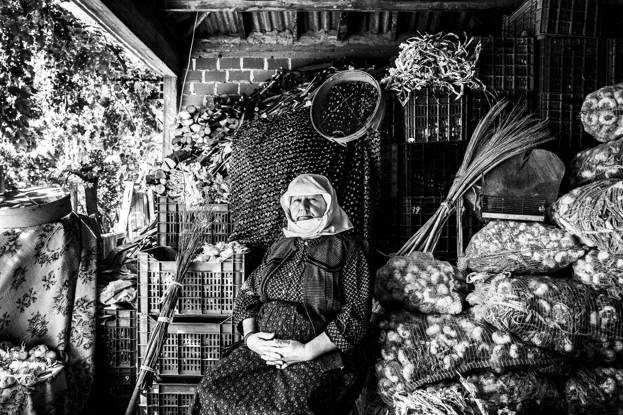 Traditional work costume at an outdoor garlic storing place in Nea Vyssa, Evros, Thrace, Greece, by photographer George Tatakis