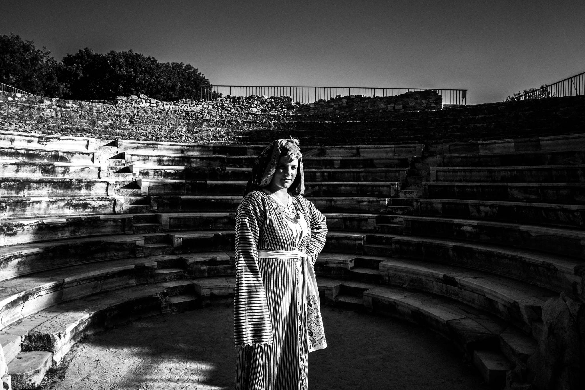 Traditional costumes in Kos in front of an ancient theater by photographer George Tatakis