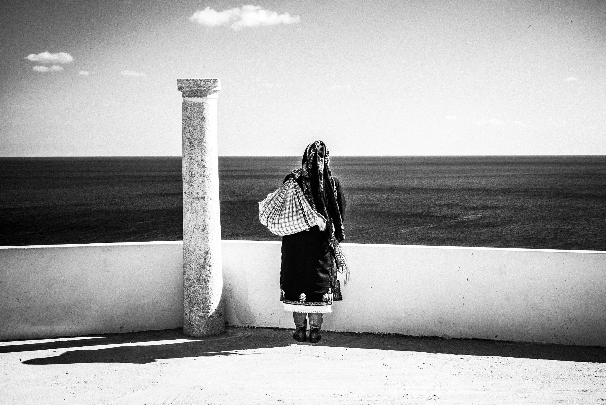 Overlooking the sea during the festival of St. Minas, Olympos, Karpathos, Greece. Black and white photography by George Tatakis