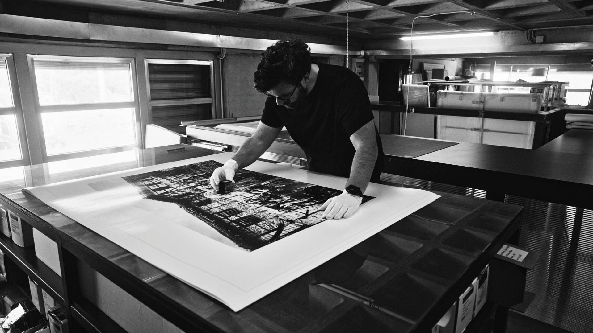 George Tatakis inspecting a large black-and-white fine-art print during the production of the Caryatis exhibition.
