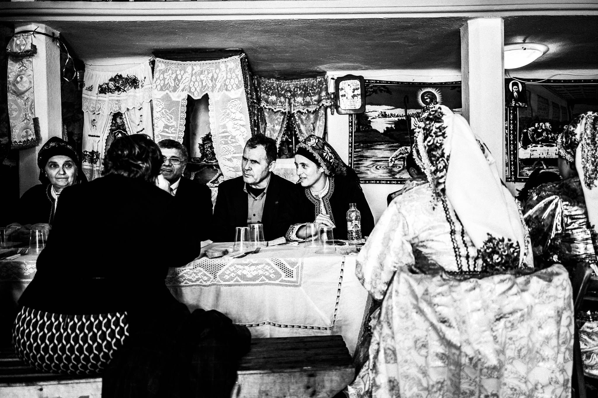 A family gathered around a table, waiting for lunch, inside the main church. Olympos, Karpathos, Greece. 