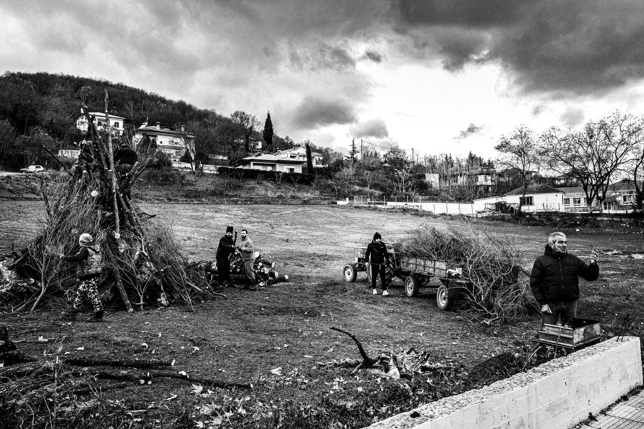 Working on building up the pile of woods at Sotira, Pagan Christmas customs of Northern Greece, by photographer George Tatakis