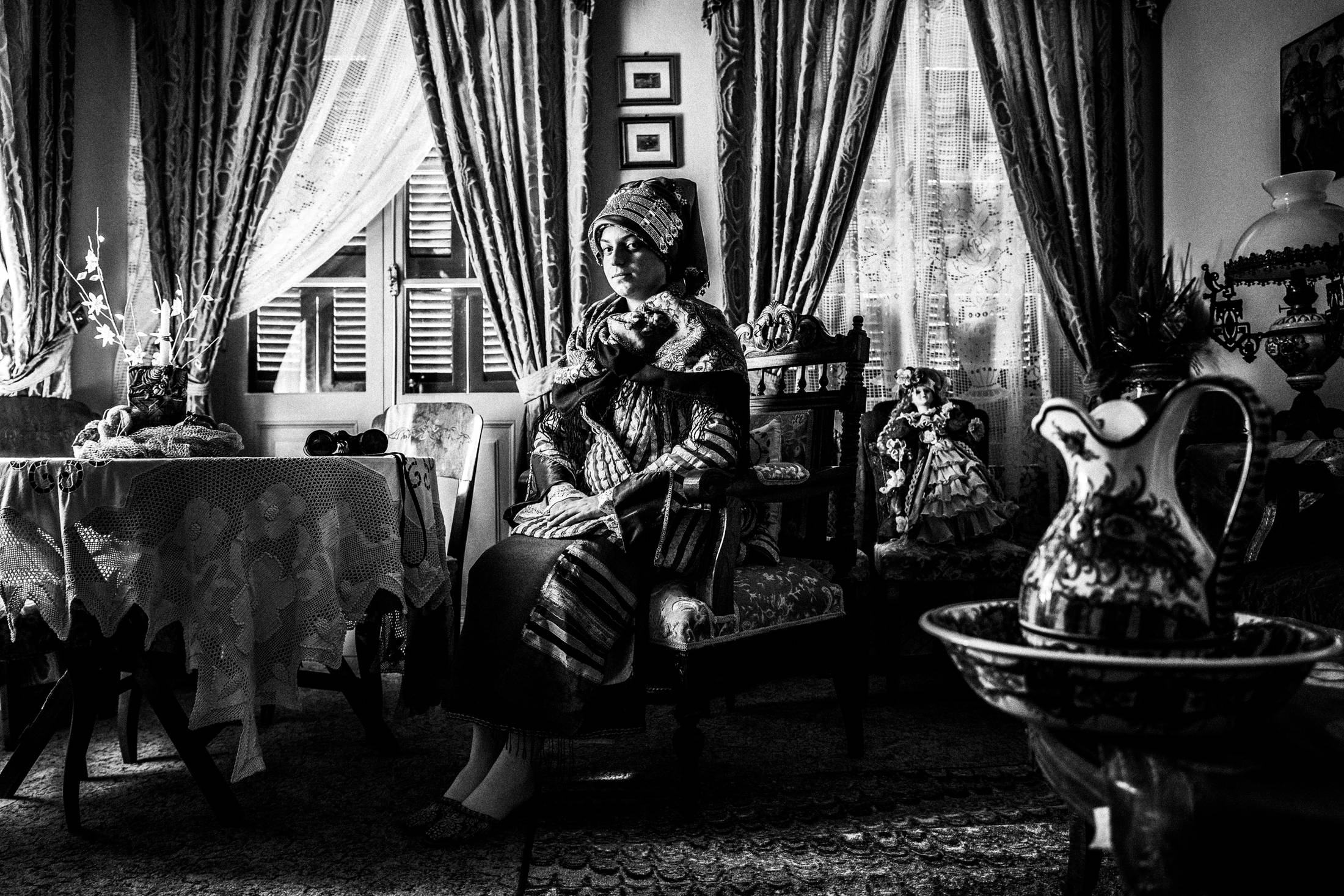 Inside a local traditional house in Symi wearing the traditional costumes, by photographer George Tatakis