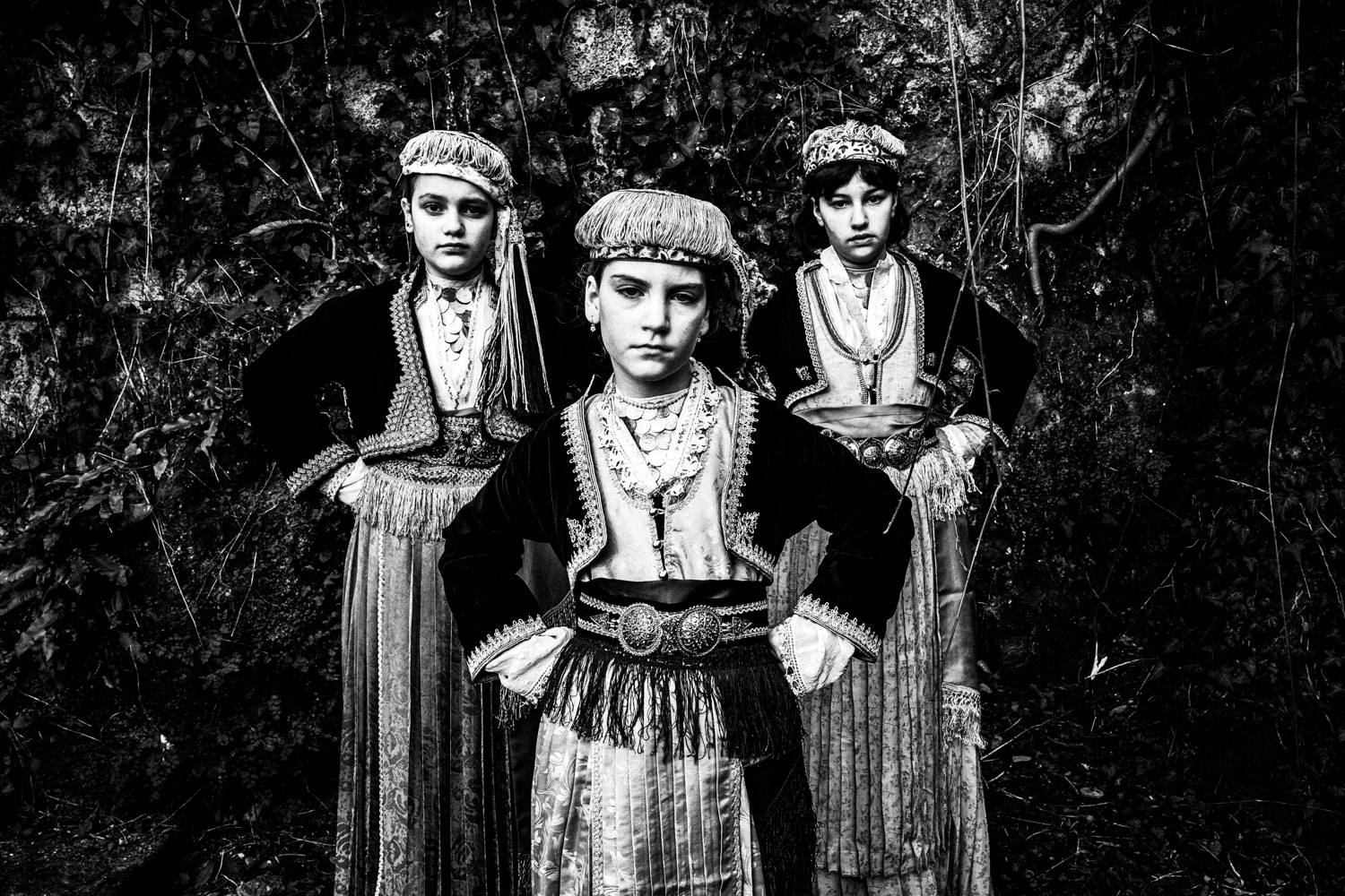 Three girls in the traditional attire of Naoussa, Imathia, Macedonia, Greece. Black and white photograph by George Tatakis
