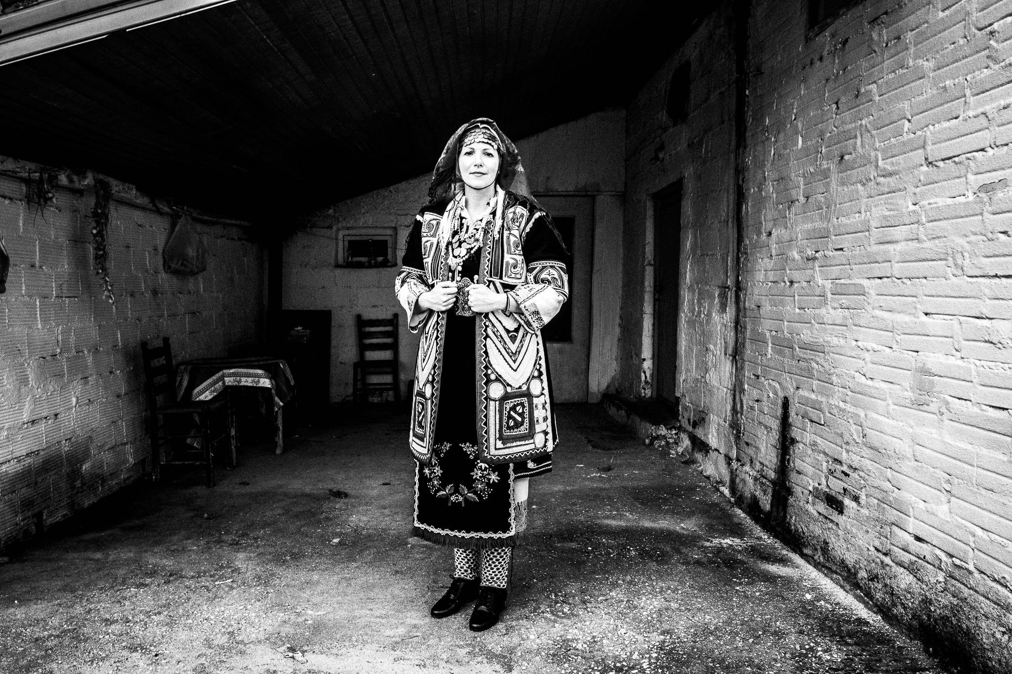 A woman in the local costume, Pagan Christmas customs of Northern Greece, by photographer George Tatakis