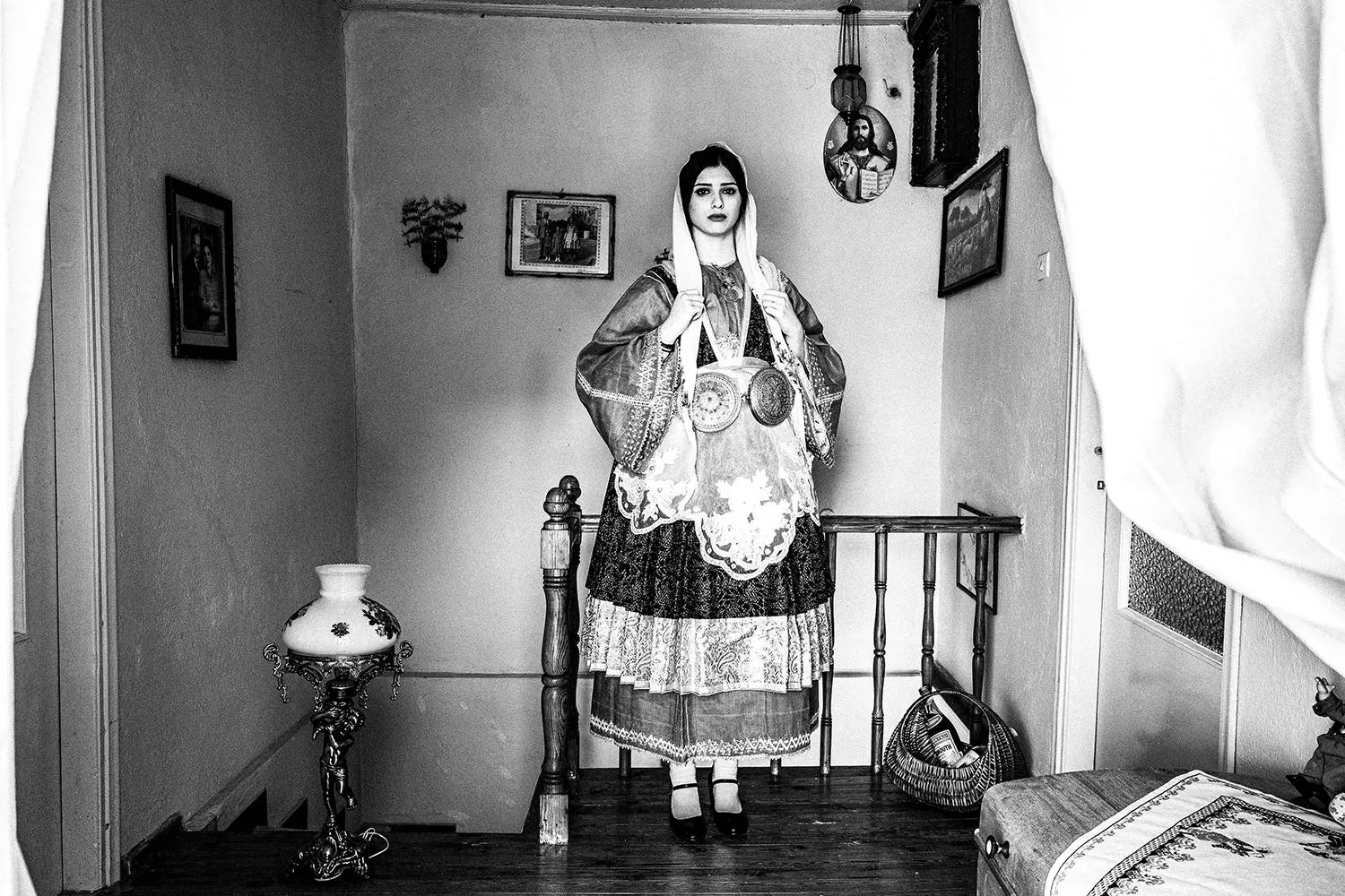 Ένα όμορφο κορίτσι σε μια σκάλα, φορώντας την παραδοσιακή φορεσιά του Τρίκερι, Θεσσαλία, Ελλάδα. Ασπρόμαυρη φωτογραφία του Γιώργου Τατάκη