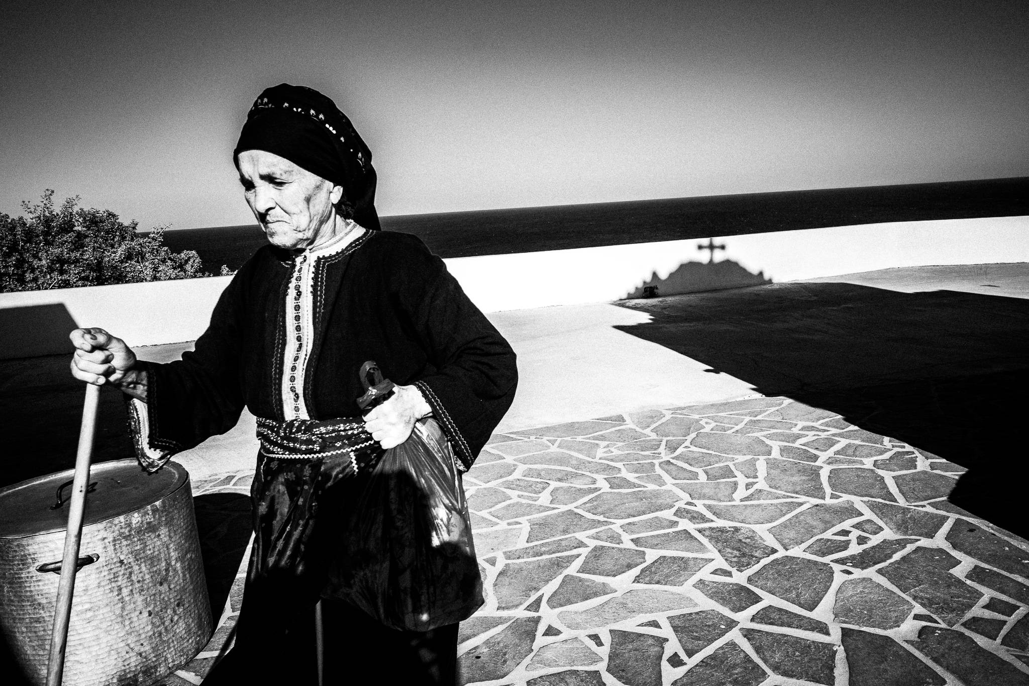 In the church courtyard during a traditional baptism in St. Minas, Olympos, Karpathos, Greece. Black and white photography by George Tatakis