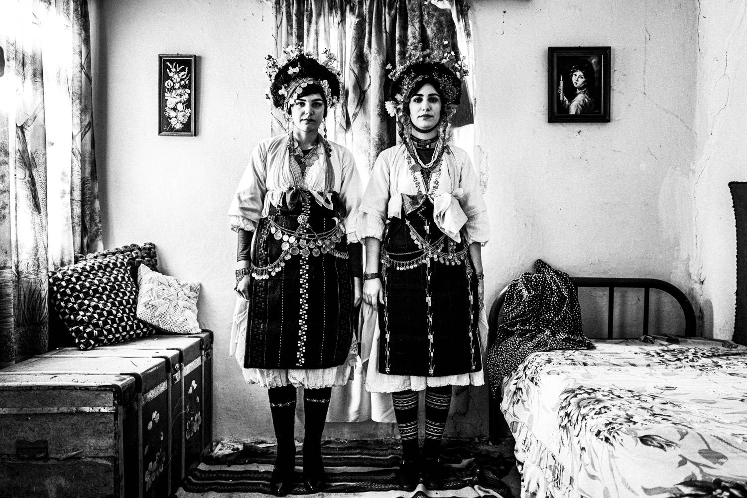 Two Lazarines posing inside a local old house. Meliki, Imathia, Macedonia, Greece. Black and white photograph by George Tatakis