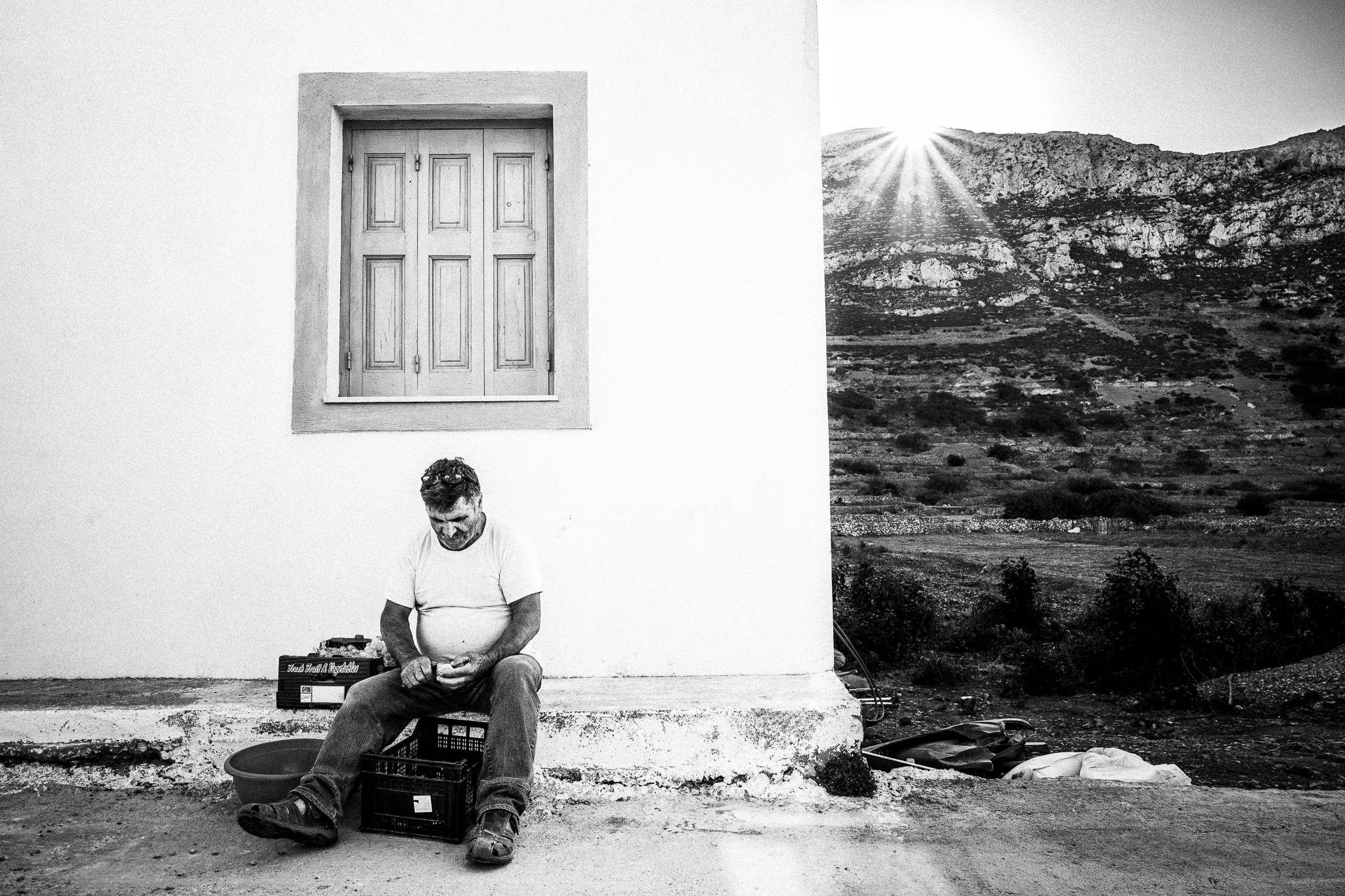Michalis preparing the food in Avlona, Olympos, Karpathos, Greece. Black and white photography by George Tatakis