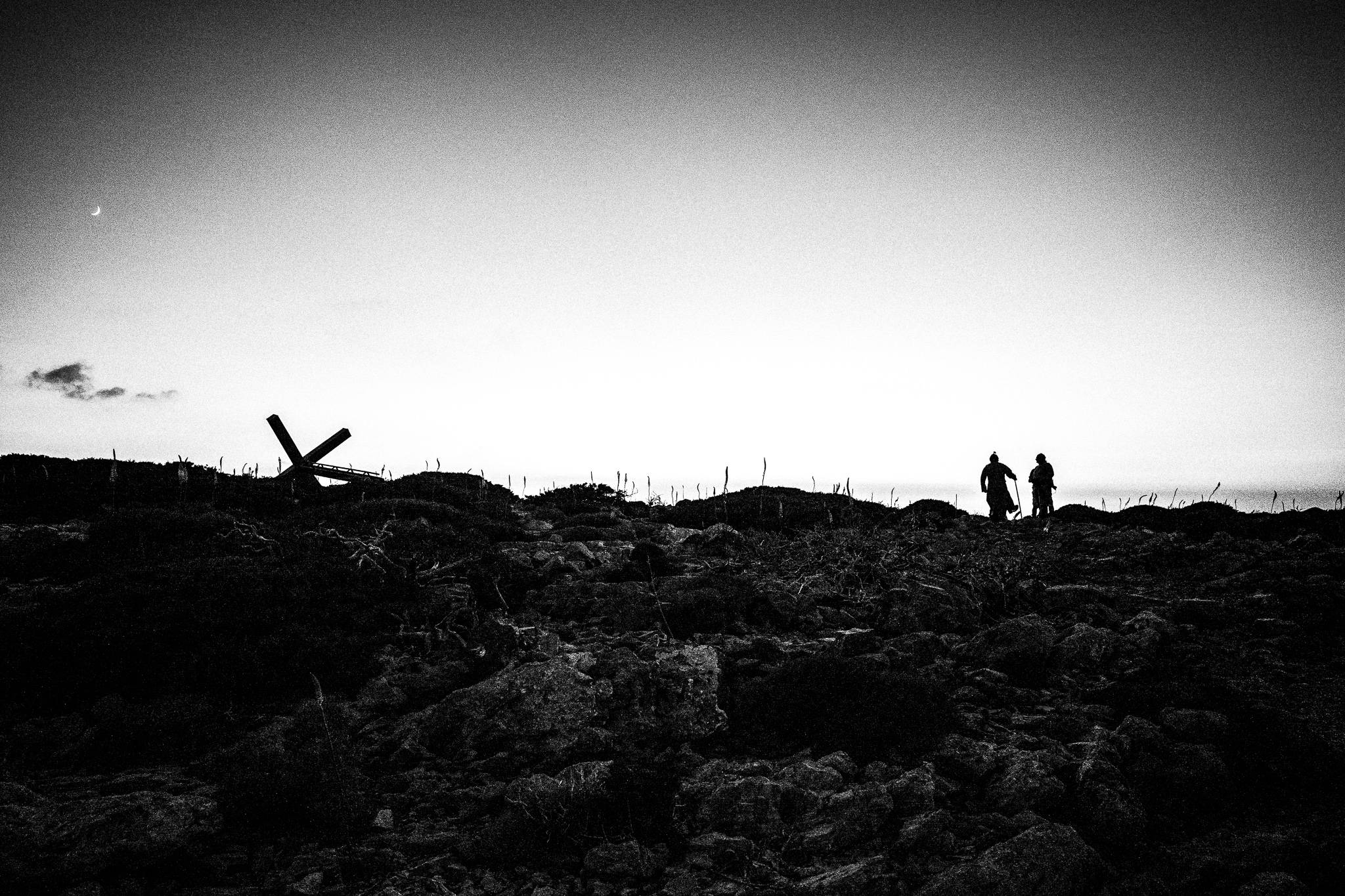 Walking back to the city for the feast of St. Zacharias at Argos on the island of Saria, Olympos, Karpathos, Greece. Black and white photography by George Tatakis