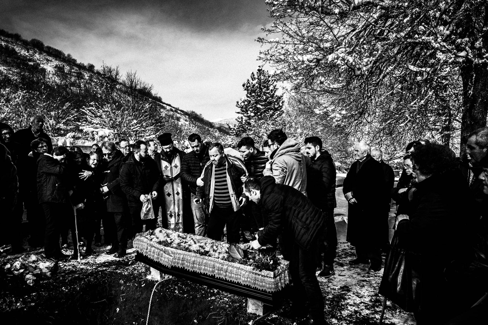 A funeral service taking place at the cemetery of Volax, Pagan Christmas customs of Northern Greece, by photographer George Tatakis